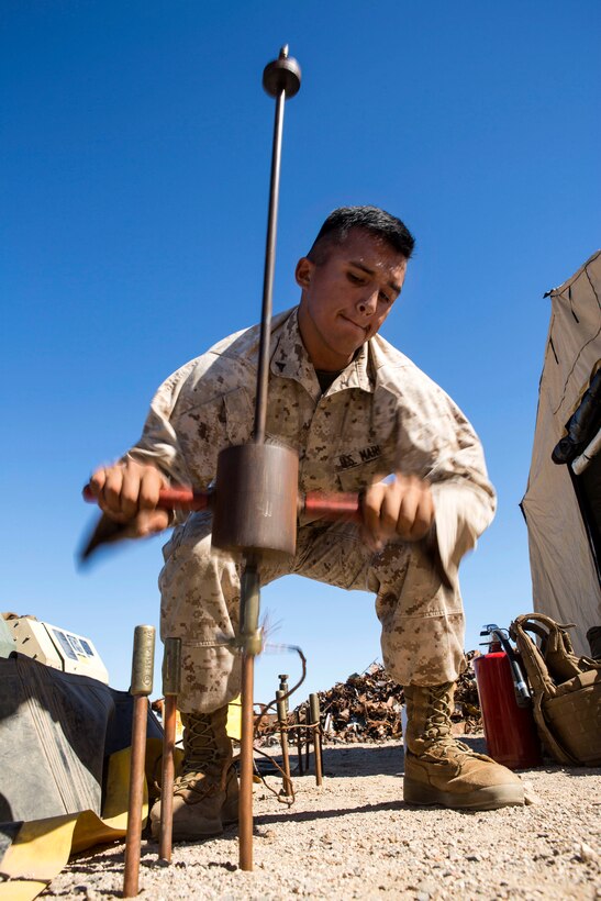 Marine Corps Lance Cpl. Modesto Martinez uses a sliding hammer on grounding rods during a casualty evacuation exercise at Fire Base Burt, Chocolate Mountain Aerial Gunnery Range, Calif., Oct. 22, 2015. Martinez is assigned to 1st Medical Battalion, 1st Marine Logistics Group. U.S. Marine Corps photo by Lance Cpl. Roderick L. Jacquote 