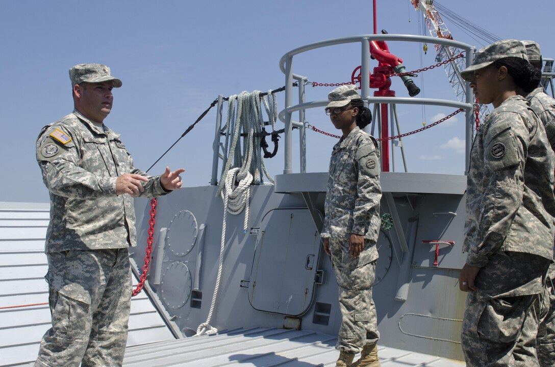 Sgt. 1st Rodney Buras from New Orleans, La., familiarizes Pvt. Keonna Dunkley, Prince Georges County, Va., (left) and Pfc. Aleeya Smith (right) Soldiers with a Landing Craft Mechanized watercraft (LCM). The 3rd Transportation Brigade (Expeditionary) Soldiers were on Fort Eustis during annual training taking part in Terminal Warrior 2015. The Logistics-Over-the-Shore (LOTS) exercise took place in the Hampton Roads area of Virginia from mid July through mid August and included Reserve, National Guard and active duty units focused on cohesion and sharpening proficiency in basic LOTS skills as part of the Total Army Concept.
