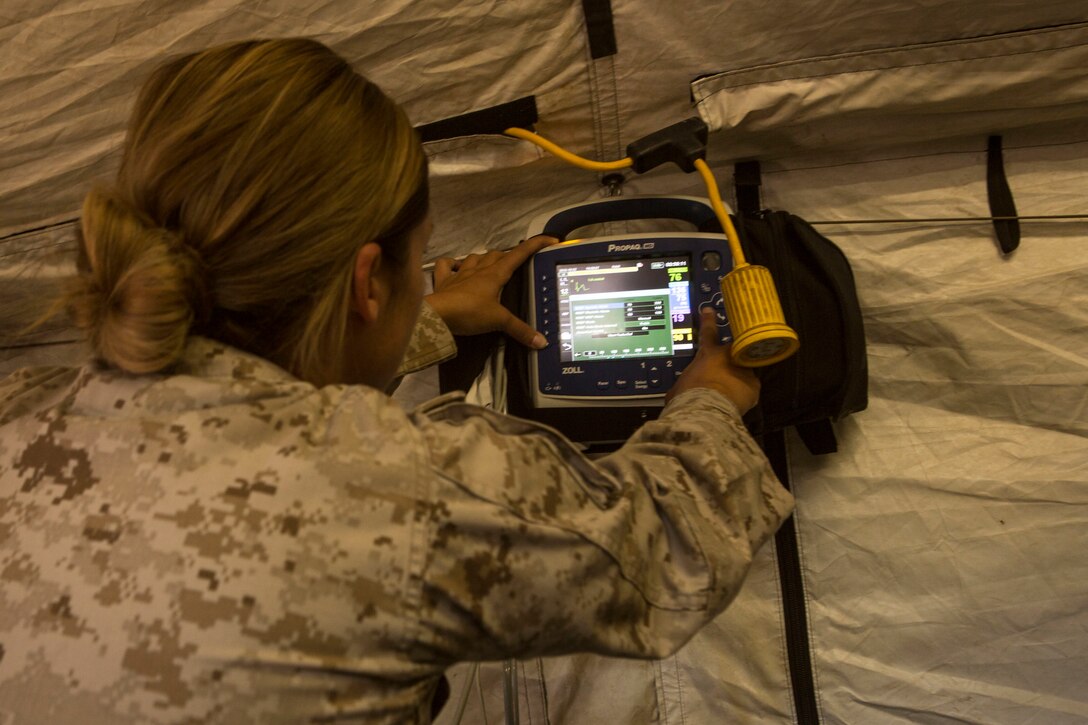 Navy Lt. Domenique Selby checks a monitor during a casualty evacuation exercise at Fire Base Burt, Chocolate Mountain Aerial Gunnery Range, Calif., Oct. 22, 2015. Selby is assigned to 1st Medical Battalion, 1st Marine Logistics Group. U.S. Marine Corps photo by Lance Cpl. Roderick L. Jacquote 