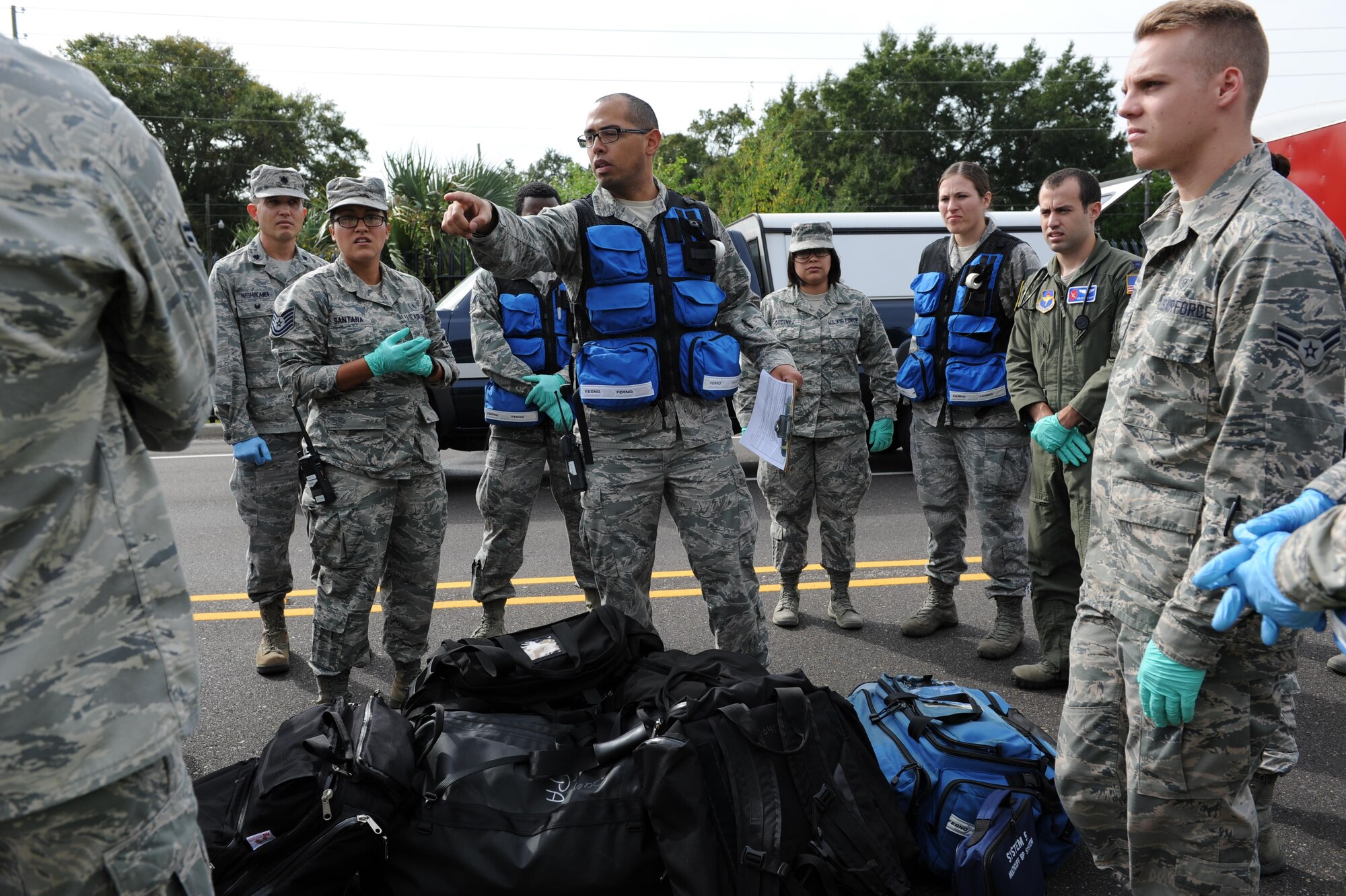 Staff Sgt. Juan Santana, 81st Aerospace Medicine Squadron base operational medicine cell standards NCO in charge, assigns medical personnel to various triage areas during a Chemical, Biological, Radiological and Nuclear exercise scenario, Oct. 22, 2015, Keesler Air Force Base, Miss. The Force Protection Condition exercise scenario included an intruder simulating releasing gas to cause a mass casualty event. Airmen who were returning from physical training simulated receiving skin, eye and lung burns from exposure to the chemical. (U.S. Air Force photo by Kemberly Groue)