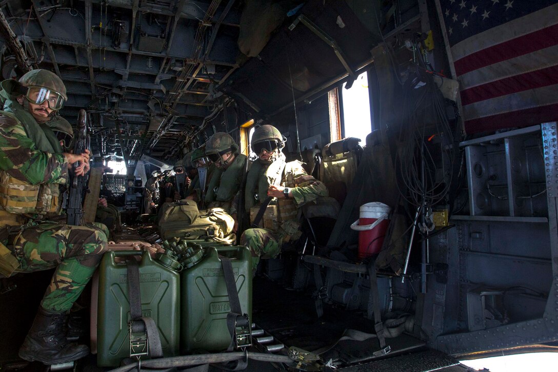U.S. and Portuguese Marines sit aboard a Marine Corps CH-53E Sea Stallion helicopter flying to participate in a combined helicopter assault training near Pinheiro Da Cruz Beach, Portugal, Oct. 21, 2015, during exercise Trident Juncture 15. The helicopter crew is assigned to the 26th Marine Expeditionary Unit, embarked aboard the amphibious transport dock ship USS Arlington. Trident Juncture is a NATO-led exercise designed to certify response forces and develop interoperability among participating NATO and partner nations. U.S. Marine Corps photo by Sgt. Austin Long