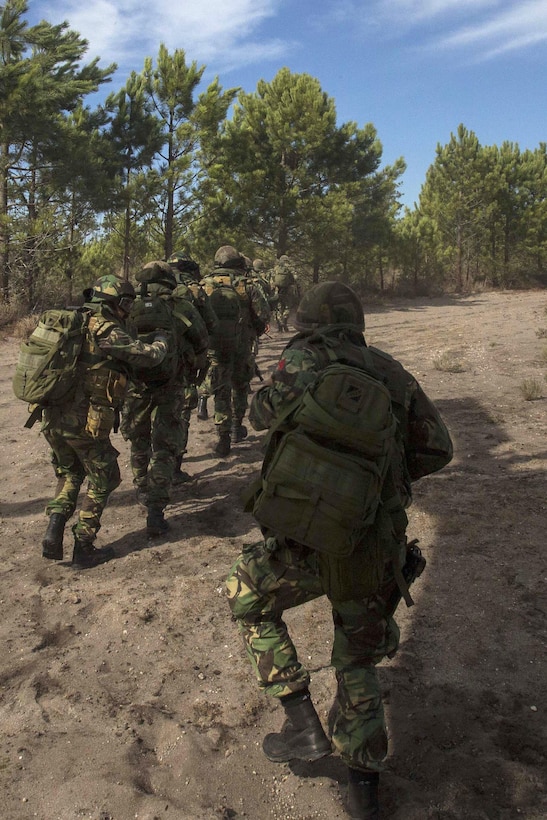 Portuguese Marines advance to their first objective after unloading from a U.S. Marine Corps CH-53E Sea Stallion helicopter to participate in a combined helicopter assault training near Pinheiro Da Cruz Beach, Portugal, Oct. 21, 2015, during exercise Trident Juncture 15. U.S. Marine Corps photo by Sgt. Austin Long 