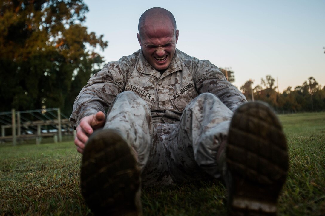 Marine Corps Pfc. Brandon Tressler conducts a max set of sit-ups after completing a 1.5 mile ruck run on Camp Lejeune, N.C., Oct. 20, 2015. The screener prepares candidates for the Scout Sniper Basic Course. Tressler is a scout sniper screener candidate from 3rd Battalion, 6th Marine Regiment. U.S. Marine Corps photo by Cpl. Kirstin Merrimarahajara