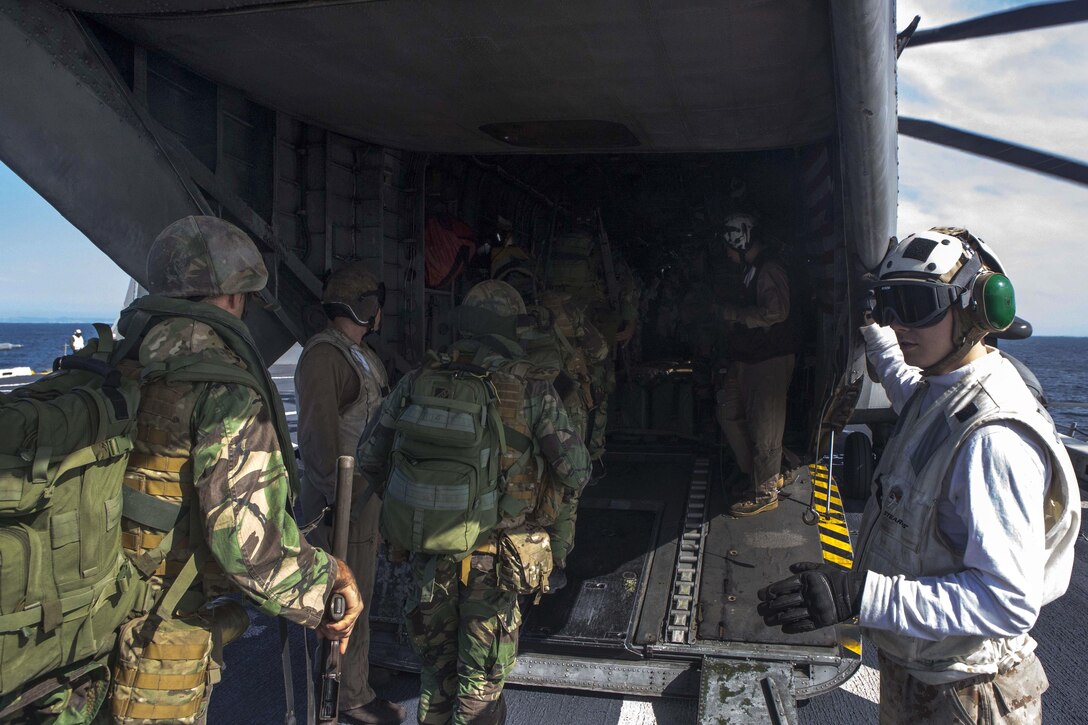 U.S. and Portuguese Marines load into a U.S. Marine Corps CH-53E Sea Stallion helicopter aboard the amphibious transport dock ship USS Arlington in preparation for a combined helicopter-borne assault training near Pinheiro Da Cruz, Praia Da Raposa, Portugal, Oct. 21, 2015 during exercise Trident Juncture 15. U.S. Marine Corps photo by Sgt. Austin Long