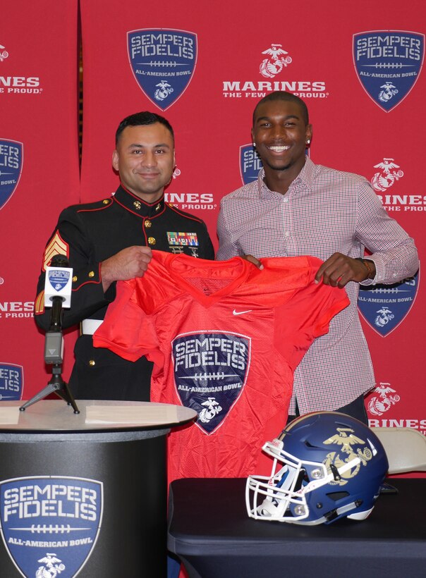 Staff Sgt. Armando Santana, recruiter with Recruiting Sub Station Thousand Oaks, presents Theo Howard with a jersey for the 2016 Semper Fidelis All-American Bowl at Westlake High School in Westlake Village, Oct. 8, 2015. (Courtesy photo) 