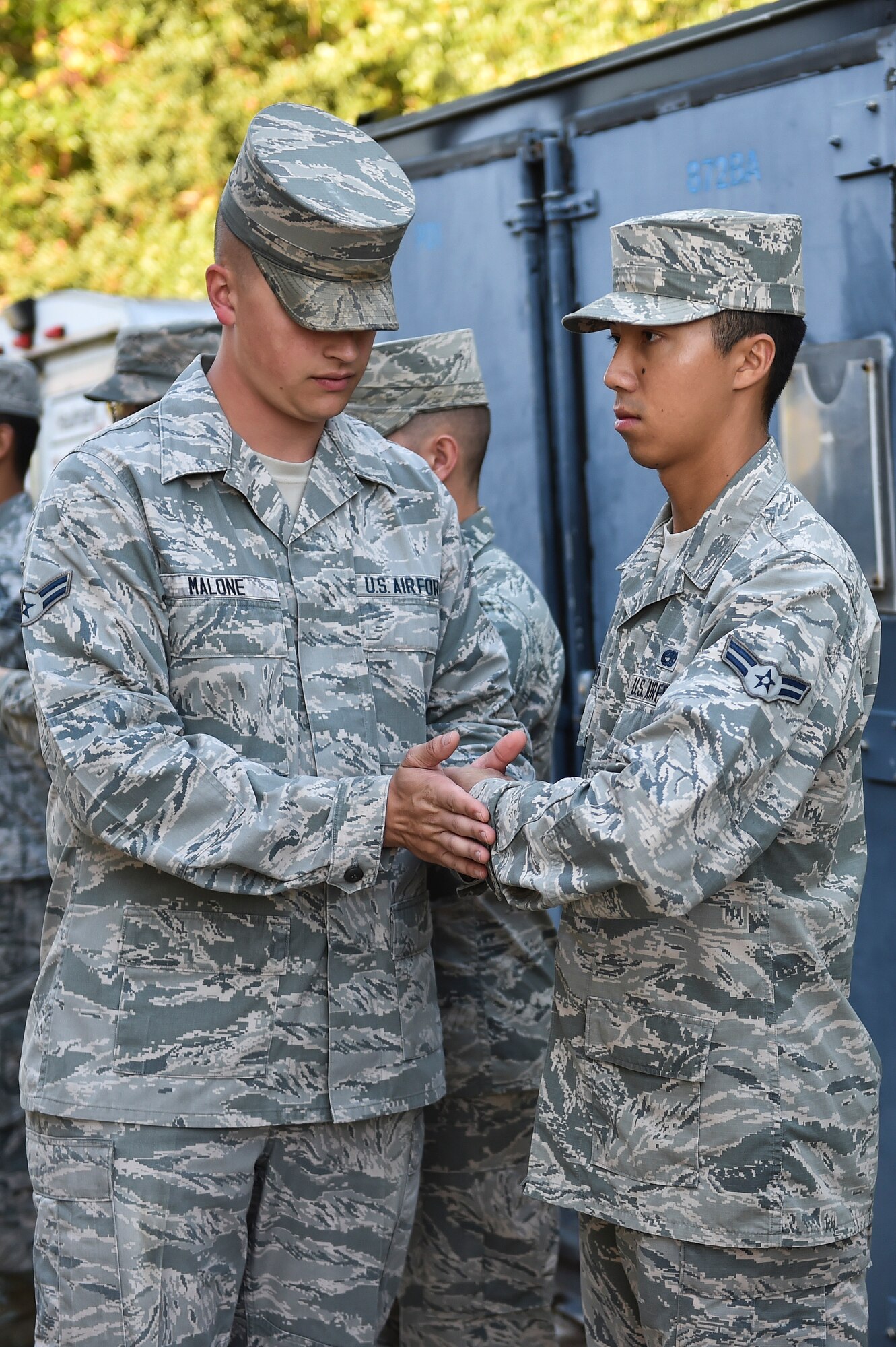 Airman 1st Class Cody Malone, U.S. Air Force Honor Guard mobile training team instructor, adjusts the hand of A1C Raymond Everton, Hurlburt Field Honor Guard member, during training at Hurlburt Field, Fla., Oct. 16, 2015. Base honor guard members from Hurlburt Field, Eglin Air Force Base and Tyndall AFB, Fla., received training from the U.S. Air Force Honor Guard mobile training team during a seven-day standardization course. (U.S. Air Force photo by Senior Airman Jeff Parkinson)

