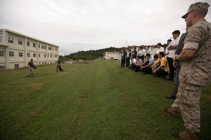Police officers and officials with the Okinawa Prefectural Police observe a military working dog demonstration during a tour of the Provost Marshal's Office Oct. 23 aboard Camp Foster, Okinawa, Japan. The visit was part of an effort by PMO and OPP to learn about one another's operations and build upon an already fruitful partnership between the two organizations, according to Sgt. Hiroki Ashitomi, an officer with the 2nd Criminal Investigation Section, OPP.