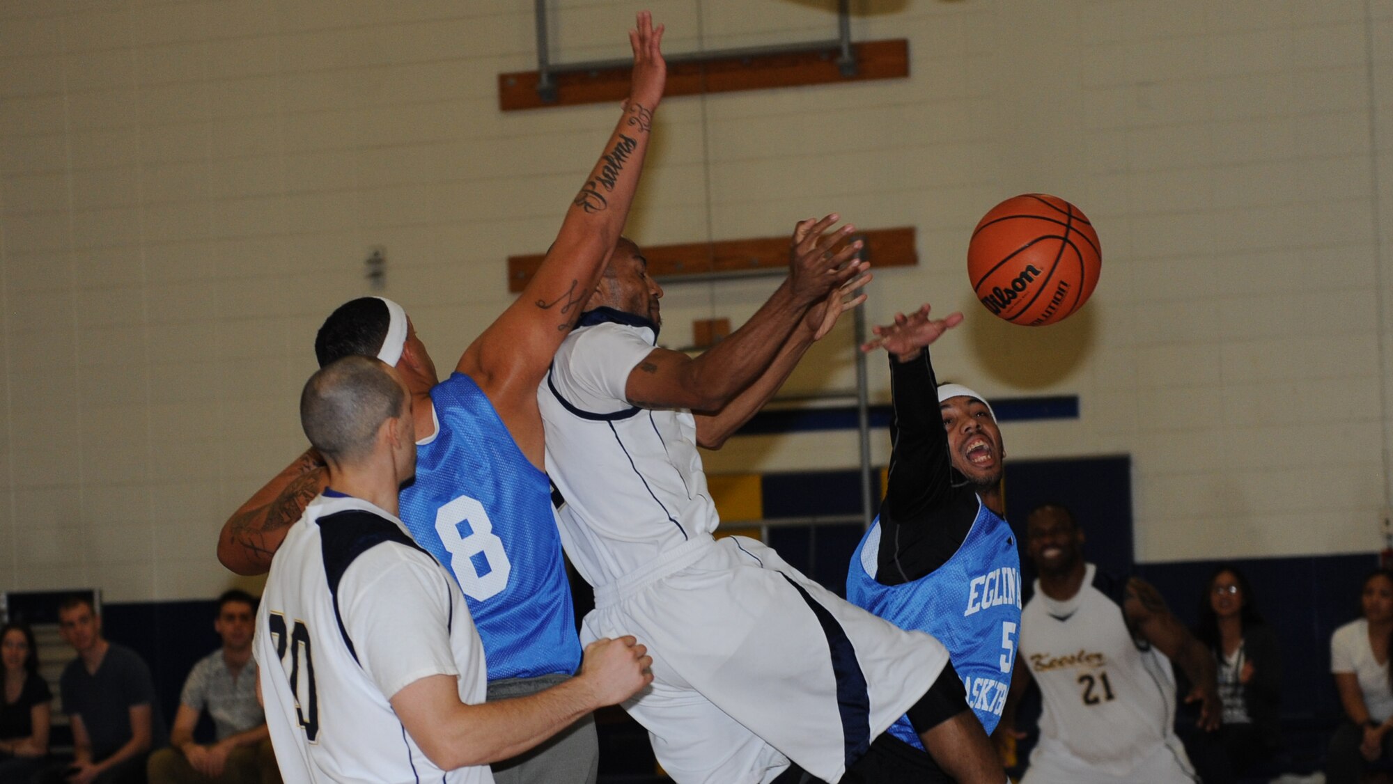 Members from Keesler Air Force Base and Eglin AFB, Fla. reach for the ball during a men’s varsity basketball game against, Oct. 24, 2015, Keesler Air Force Base, Miss. Keesler defeated Eglin, 90-87. (U.S. Air Force photo by Kemberly Groue)