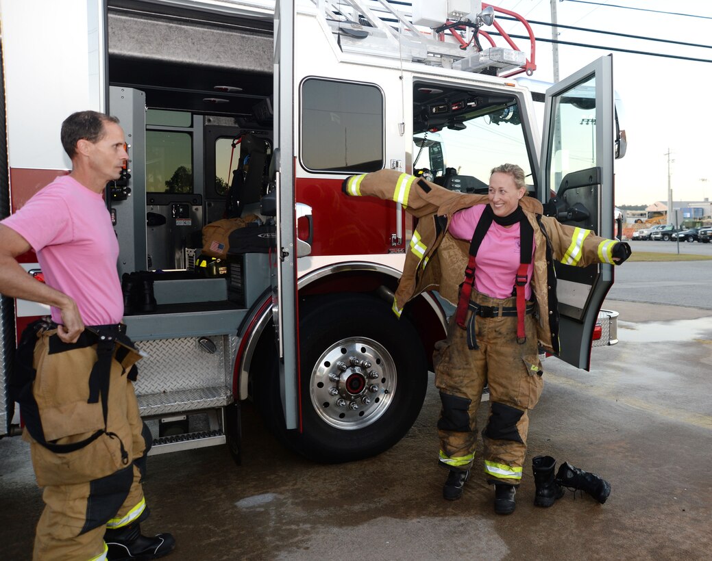 Firefighter/paramedic Ron Hedgecoke and emergency medical technician/firefighter Megan Cornell, both Fire Department personnel at Marine Corps Logistics Base Albany, suit up in response to a call during a simulated drill on the installation, recently. In keeping with the traditional October uniform-of-the-day, the duo wore pink T-shirts as a symbol of the department’s efforts to heighten awareness and to show support in the fight against breast cancer.