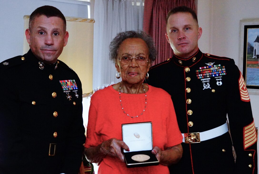 Mrs. Pauline Wallick, widow of Montford Point Marine Robert Wallick, is presented with a Congressional Gold Medal at her home Oct. 23, 2015, by Lt. Col. Michael F. Arnone, Inspector-Instructor 1st Battalion, 24th Marine Regiment, 4th Marine Division, and Sgt. Maj. Joseph S. Gregory, Inspector-Instructor sergeant major of 1/24.  The Congressional Gold Medal is the highest civilian honor bestowed by Congress for distinguished achievement.  The President of the United States, President Barack Obama signed into law, the legislation to award the Congressional Gold Medal to Montford Point Marines on Nov. 23, 2011.  This award recognizes Montford Point Marines' contributions to the Marine Corps and the United States of America from 1942 to 1949, when approximately 20,000 African American recruits were trained at a segregated base called Camp Montford Point. 
