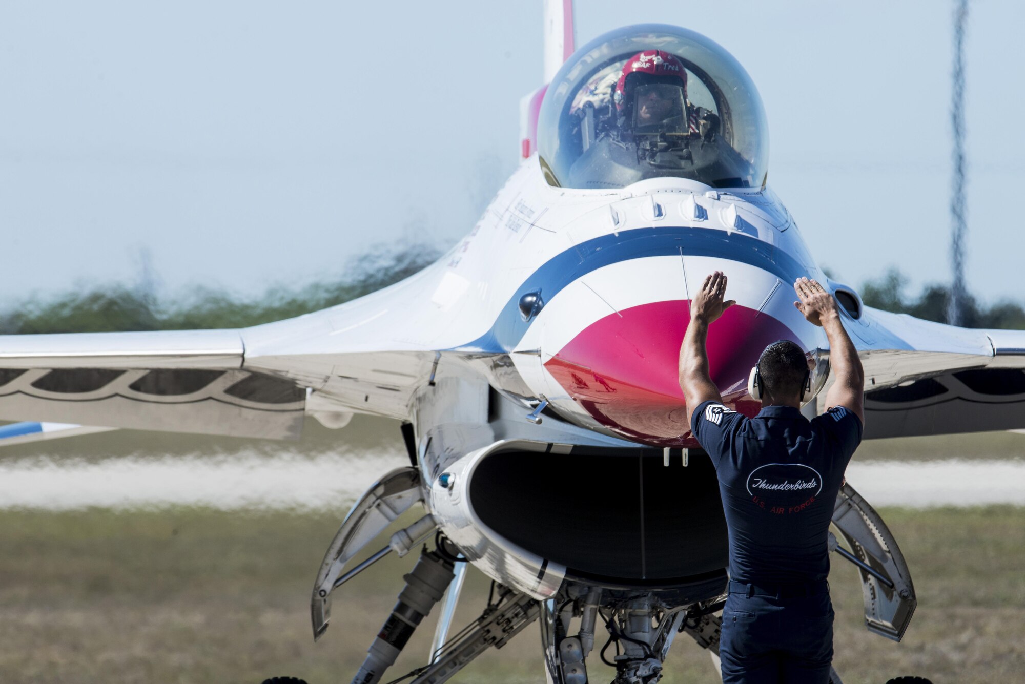 Tech. Sgt. Christopher Audet, U.S. Air Force Aerial Demonstration Squadron “Thunderbirds” tactical aircraft maintainer, guides Capt. Nicholas Eberling, U.S. Air Force Air Demonstration Squadron “Thunderbirds” opposing solo pilot, as he lands at Joint Base San Antonio-Randolph Oct. 26, 2015. The Thunderbirds perform for people all around the world, combining years of training and experience with an attitude of excellence to showcase what the Air Force is all about. (U.S. Air Force photo by Airman 1st Class Stormy Archer/Released)
