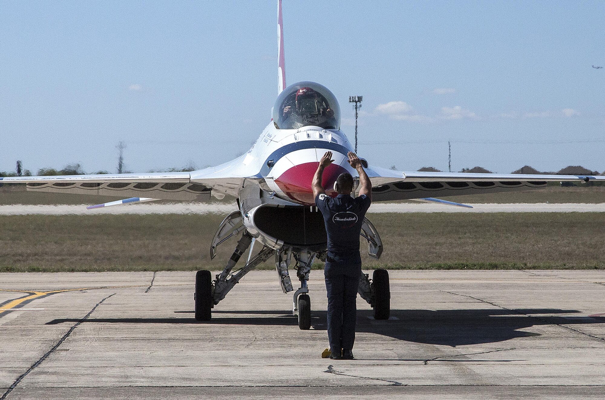 Tech. Sgt. Christopher Audet, U.S. Air Force Air Demonstration Squadron "Thunderbirds" tactical aircraft maintainer, guides a Thunderbird Oct. 26, 2015 at Joint Base San Antonio-Randolph, Texas. The Thunderbirds team members arrived in preparation for the 2015 JBSA-Randolph Air Show and Open House to be held Oct. 31 and Nov. 1.  Air shows allow the Air Force to display the capabilities of our aircraft to the American taxpayer through aerial demonstrations and static displays and allowing attendees to get up close and personal to see some of the equipment and aircraft used by the U.S. military today.  (U.S. Air Force photo by Johnny Saldivar/Released)