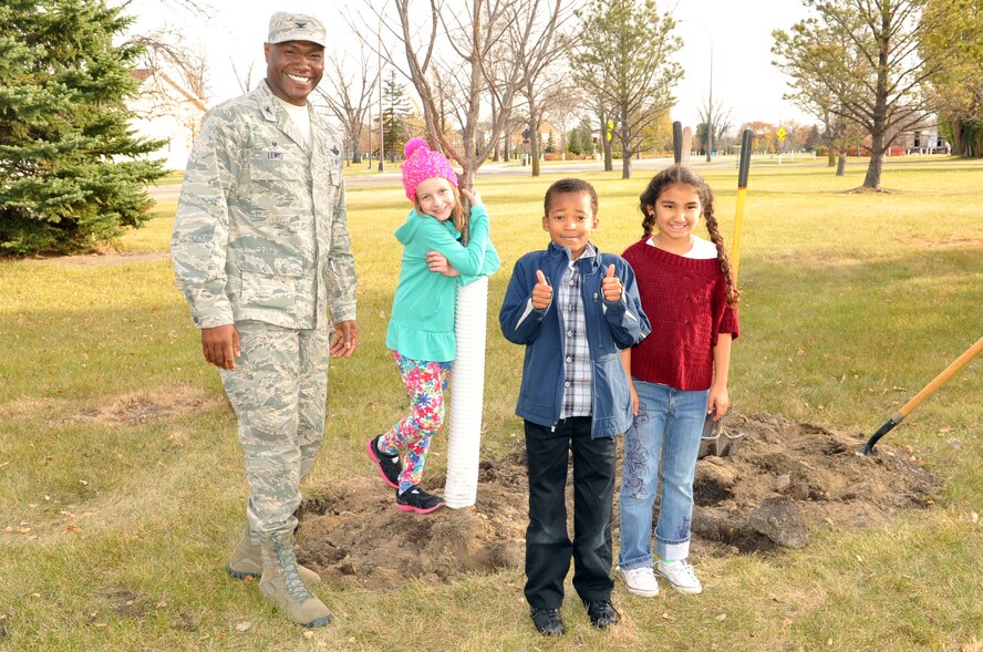 Col. Rodney Lewis, 319th Air Base Wing commander, along with several children from Grand Forks Air Force Base, celebrated Arbor Day Oct. 26, 2015, with a tree planting ceremony on the installation. Grand Forks Air Force Base, North Dakota, was awarded the Tree City USA distinction for 2014. Tree City USA is a program through the Arbor Day Foundation that recognizes communities across the country that have a tree board or department (responsible for caring for all the trees on the community’s property), a tree care ordinance, a community forestry program with an annual budget of at least $2 per capita, as well as an Arbor Day Observance or Proclamation. (U.S. Air Force photo/Staff Sgt. Susan L. Davis)