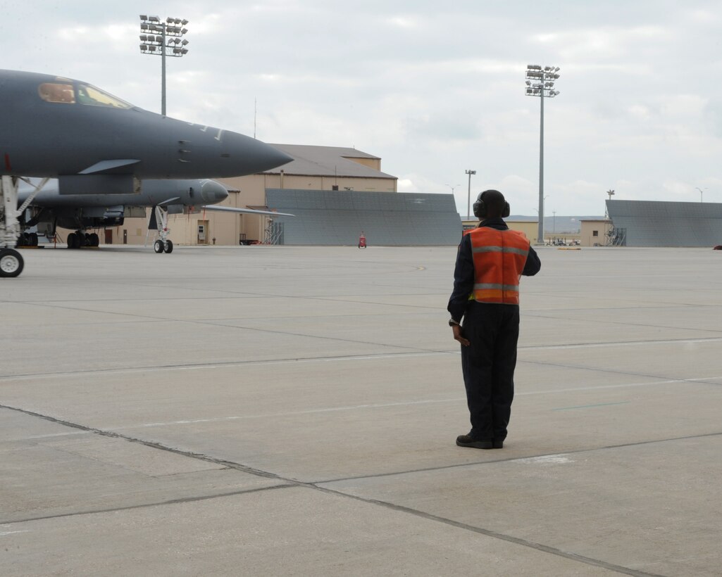An Airman from the 28th Aircraft Maintenance Squadron marshals a B-1 bomber as part of surge week at Ellsworth Air Force Base, S.D., Oct. 5, 2015. During a surge,  the wing generates nearly double the amount of sorties typically flown each week. (U.S. Air Force photo by Airman 1st Class Denise M. Nevins/Released)