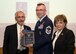 Joseph Bisognano, Air Force Association of Massachusetts president, presents Senior Master Sgt. Joseph Barden, 66th Security Forces Squadron operations superintendent, with a plaque in recognition of his selection as one on the commonwealth's "Top 5 Massachusetts Airmen" during an awards dinner at the U.S.S. Constitution in Charlestown, Mass., Oct. 24, while Yvonne Thurston, Minuteman Chapter of the AFA, stands by. Master Sgt. Kevin Walker, formerly the 319th Recruiting Squadron’s first sergeant who is now assigned to the 502d Contracting Squadron, Joint Base San Antonio, Texas, was also selected as one of the five Airmen highlighted during the event. (U.S. Air Force photo by Walter Santos)