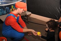 Senior Airman Alex Hawrelok, 348th Reconnaissance Squadron, leads the bean bag toss booth at Liberty Scare on Grand Forks Air Force Base, North Dakota, Oct. 23, 2015. Liberty Scare events included pumpkin decorating, costume contests and a haunted house. (U.S. Air Force photo by Airman 1st Class Bonnie Grantham/released)