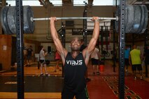 First Lt. Alex Johnson, 23rd Expeditionary Bomb Squadron electronic warfare officer, lifts weights during his functional fitness workout Oct. 21, 2015, at Andersen Air Force Base, Guam. The workout involves various exercises to include gymnastics, power lifting, cardio and Olympic weight lifting. (U.S. Air Force photo by Airman 1st Class Arielle Vasquez/Released)
