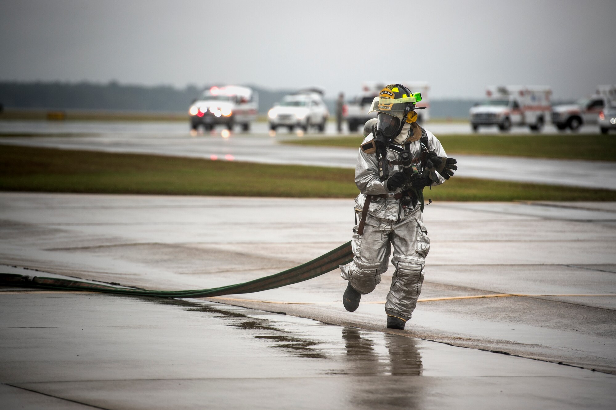 A firefighter from the 23d Civil Engineer Squadron runs towards a simulated aircraft crash scene during a major accident response exercise, Oct. 27, 2015, at Moody Air Force Base, Ga. Once the firefighters were able to put out the fire and secure the scene, they were able to assist in removing patients from the area. (U.S. Air Force photo by Senior Airman Ryan Callaghan/Released)

