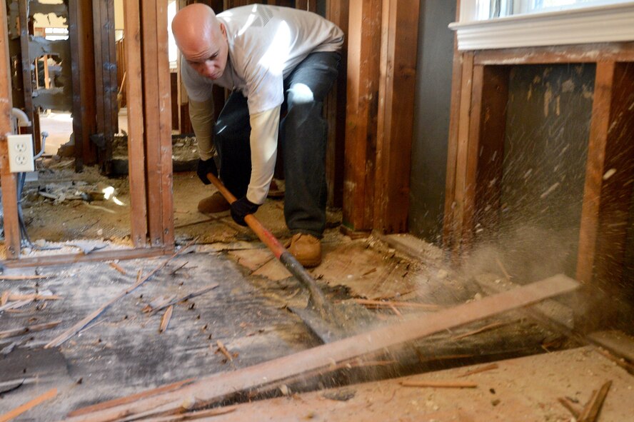 U.S. Air Force Staff Sgt. Carlos Ortiz Castillo, 20th Civil Engineer Squadron Heating, Ventilation, and Air Conditioning technician, uses a roofing shovel to remove the wood flooring of a house that was damaged by the storm that resulted from Hurricane Joaquin in Sumter, S.C., Oct. 19, 2015. Team Shaw members spent three days shift working, 10 hours a day, to assist in the disaster relief efforts in the Sumter community. (U.S. Air Force photo by Senior Airman Diana M. Cossaboom/Released)