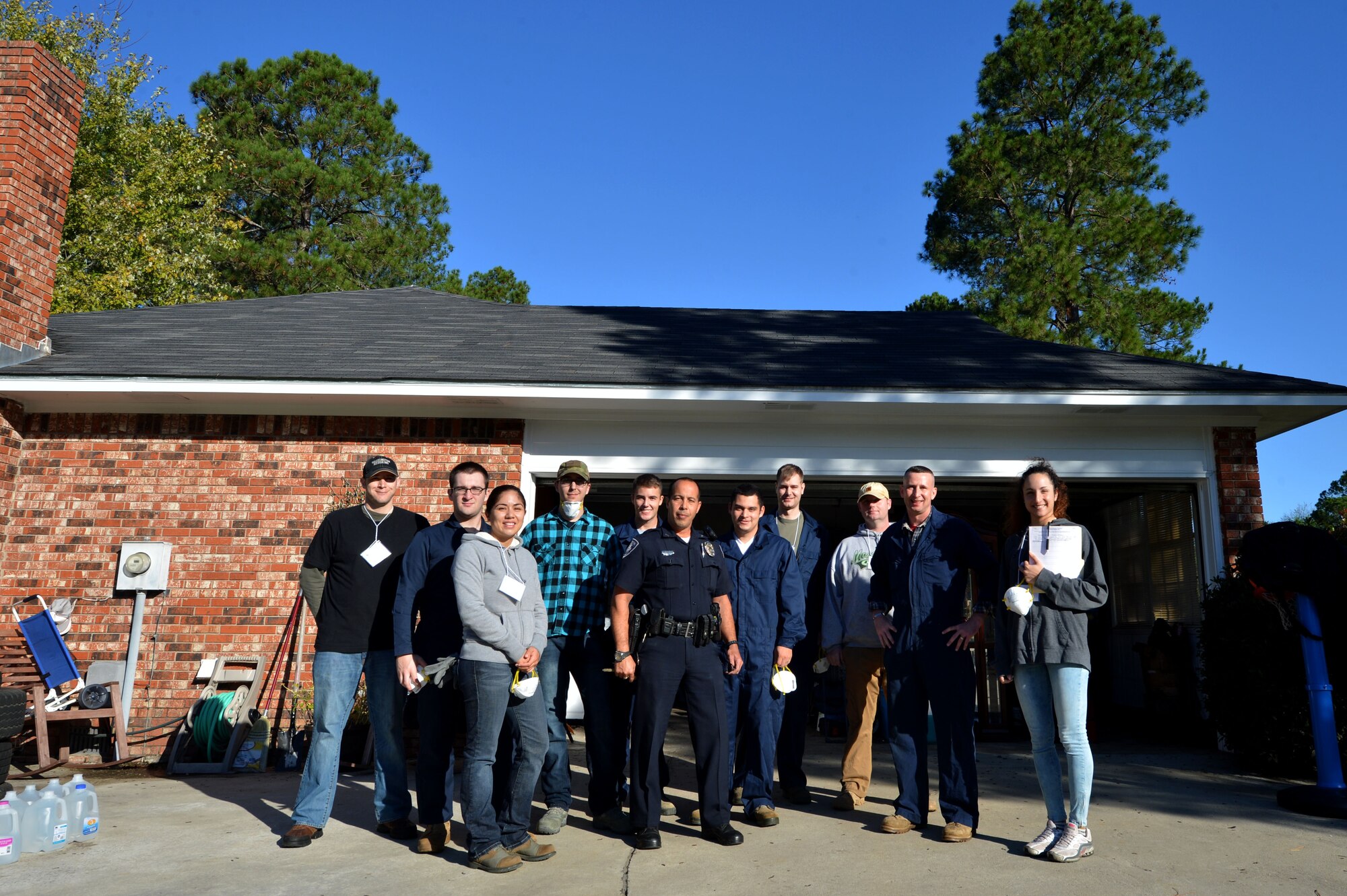 U.S. Air Force Airmen assigned to the 20th Fighter Wing stand with a Sumter County police officer and the homeowner of a residence affected by flood waters in Sumter, S.C., Oct. 17, 2015. Shaw Air Force Base, S.C. Airmen have spent the last several weeks volunteering with multiple organizations to assist with the disaster relief efforts in the Sumter area. (U.S. Air Force photo by Senior Airman Michael Cossaboom/Released)