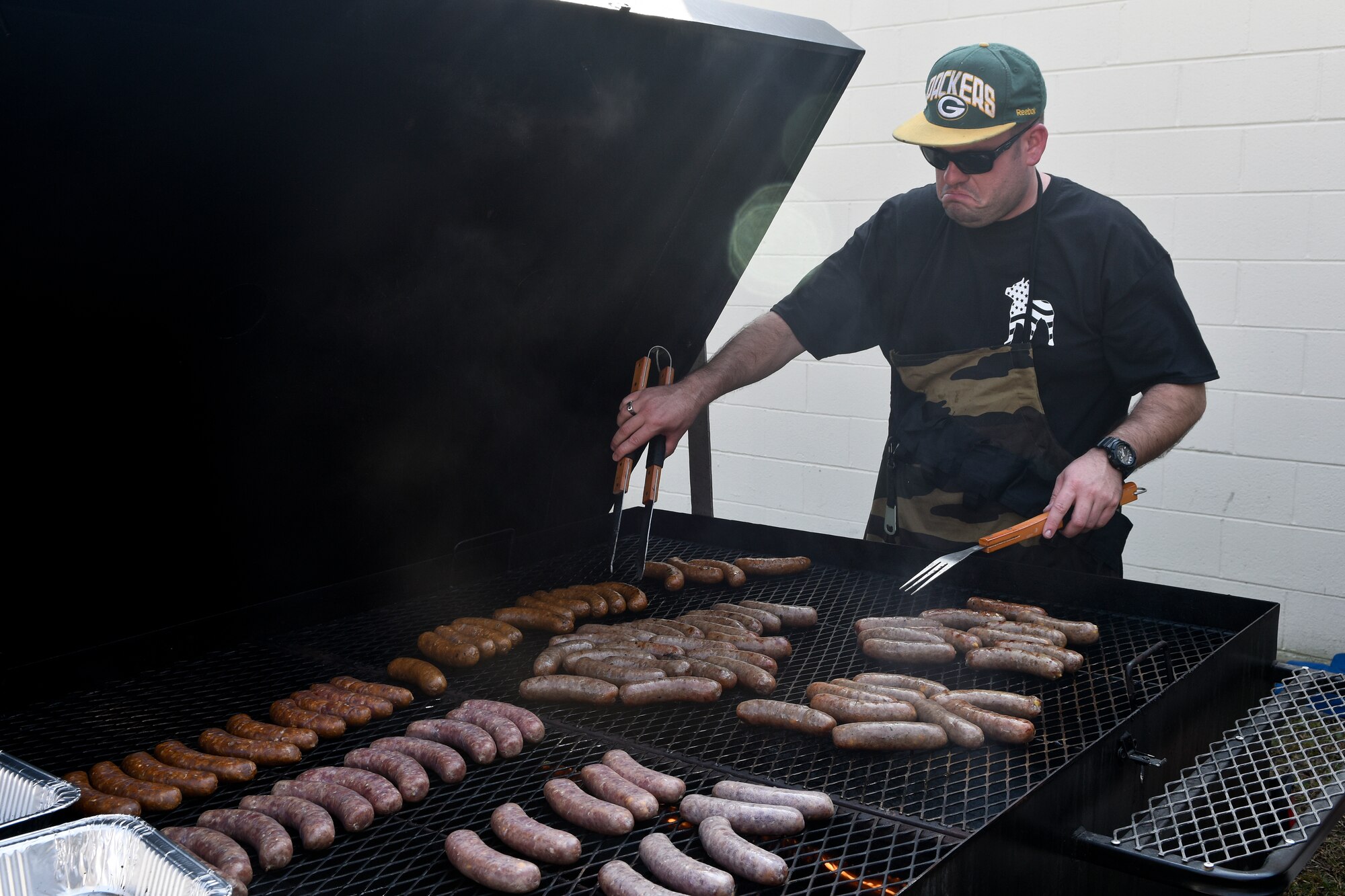 Staff Sgt. Leo Kight-Inglesby, 4th Equipment Maintenance Squadron precision-guided munitions inspector, mans the grill during the inaugural Oktobrewfest event Oct. 24, 2015, at Seymour Johnson Air Force Base, North Carolina. Food sales generated more than $700, which was donated to the Combined Federal Campaign.  (U.S. Air Force photo/Senior Airman Aaron J. Jenne)