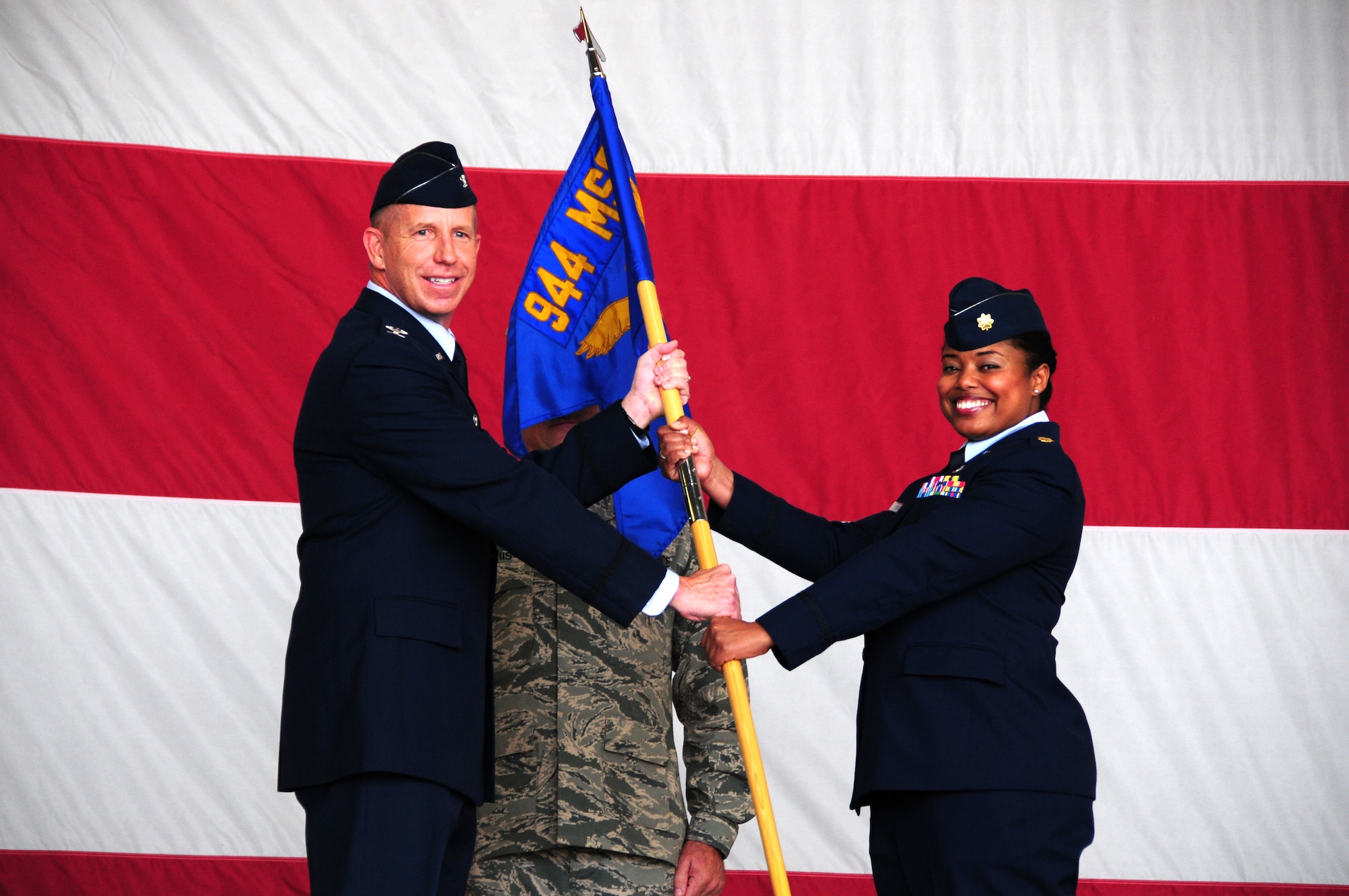 Col. Paul Theisen, 944th Mission Support Group commander, hands the squadron guidon to Maj. Melissa Greene, incoming 944th Force Support Squadron commander, during an assumption of command ceremony Oct. 25, 2015 at Luke Air Force Base. The mission of the 944th FSS is to train all assigned Reservists to perform military personnel, family readiness, services and communication functions for worldwide deployments in support of Air Force requirements. (U.S. Air Force photo by Staff Sgt. Nestor Cruz)