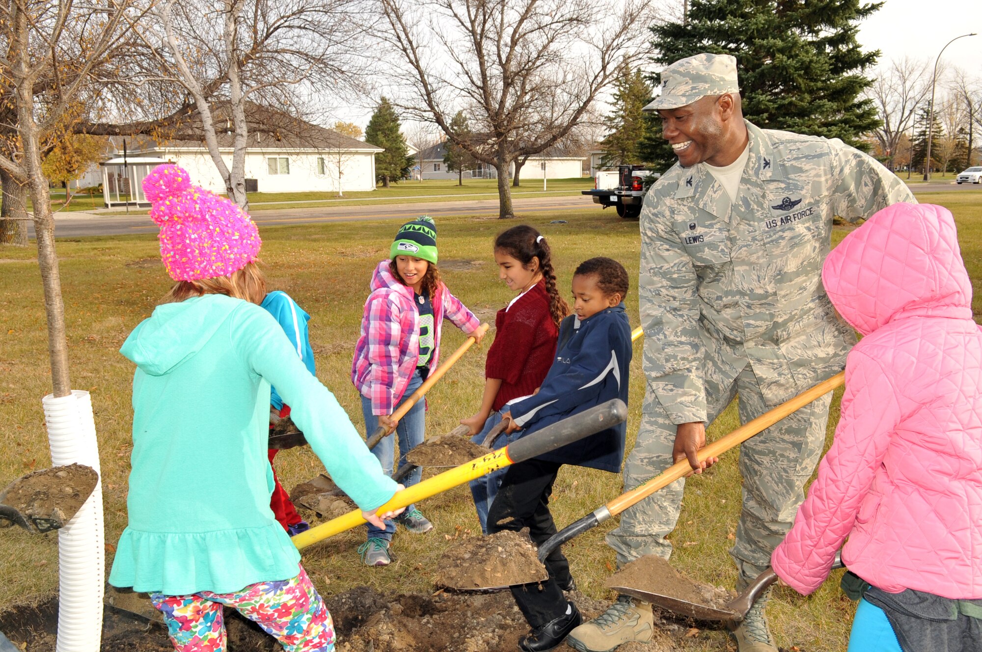 Col. Rodney Lewis, 319th Air Base Wing commander, along with several Grand Forks Air Force Base children, plants a tree to commemorate Arbor Day during a ceremony held here Oct. 26, 2015. Grand Forks Air Force Base, North Dakota, was awarded the Tree City USA distinction for 2014. Tree City USA is a program through the Arbor Day Foundation that recognizes communities across the country that have a tree board or department (responsible for caring for all the trees on the community’s property), a tree care ordinance, a community forestry program with an annual budget of at least $2 per capita, as well as an Arbor Day Observance or Proclamation. (U.S. Air Force photo/Staff Sgt. Susan L. Davis))