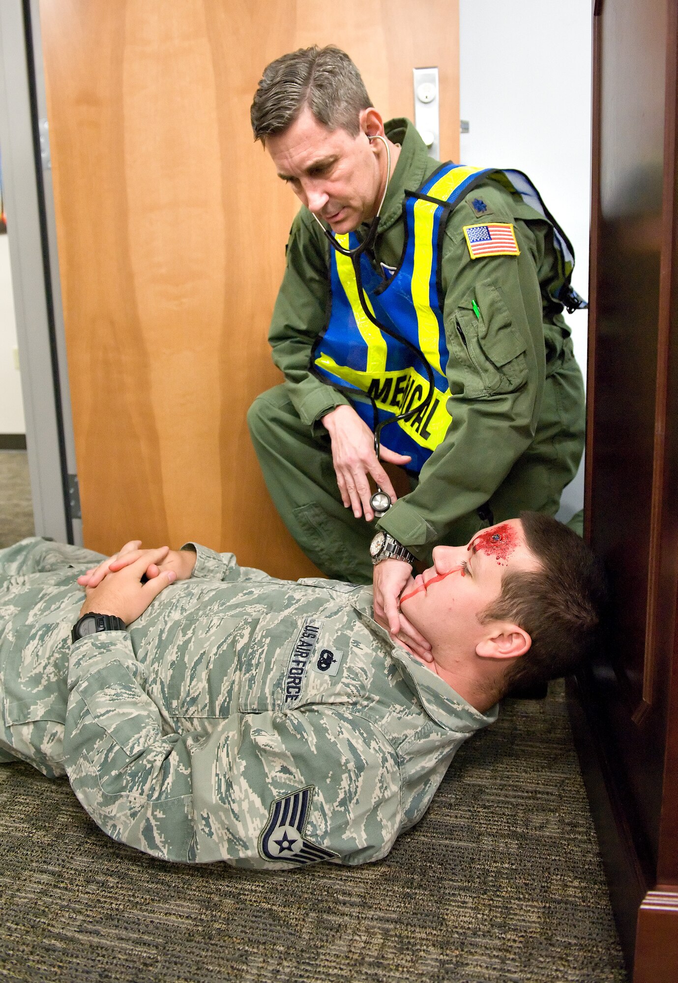 Lt. Col. Marc Neiberg, 436th Aerospace Medicine Squadron senior flight surgeon, checks simulated gunshot wound victim Staff Sgt. Cameron Chesser, 436th Maintenance Group scheduler, for vital signs as part of an active shooter scene during a major accident response exercise Oct. 20, 2015, on Dover Air Force Base, Del. Chesser, one of five simulated fatalities, suffered a simulated gunshot wound to his head presumably inflicted by a member of an East Coast terrorist cell. (U.S. Air Force photo/Roland Balik)