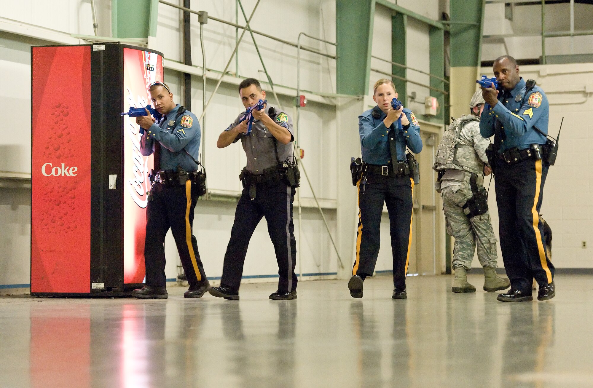 Trooper First Class David Castillo, Delaware State Police, Troop 3, left; Master Cpl. Michael Wisniewski, Dover Police Department, Dover, Del., second from left; Trooper Christine Armstrong, DSP, Troop 3, second from right; and Sgt. Bruce Harris, DSP, Troop 3, right, sweep the warehouse section of building 639 during a simulated active shooter exercise Oct. 20, 2015, on Dover Air Force Base, Del. Staff Sgt. Craig Eveland, 436th Security Forces Squadron military working dog handler and MWD Ramos kept watch to the rear of the sweep team while searching for hostages and simulated dead or injured victims. (U.S. Air Force photo/Roland Balik)