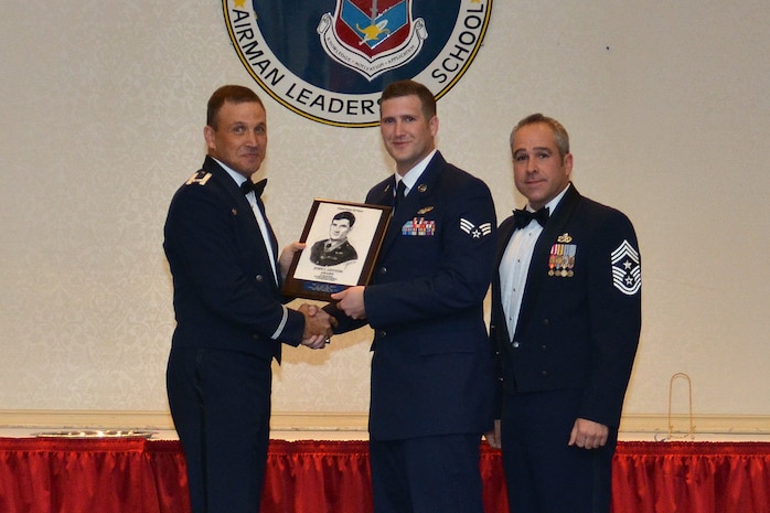 Col. Johnny Lamontagne, 437th Airlift Wing commander and Chief Master Sgt. Kristopher Berg, 437th AW command chief, present the John L. Levitow Award to Senior Airman Brian Loomis, 16th Airlift Squadron loadmaster, during the Airman Leadership School Class graduation October 22, 2015, at Joint Base Charleston - Air Base, S.C. The Levitow award is given for a student's exemplary demonstration of excellence, both as a leader and a scholar. (courtesy photo) 