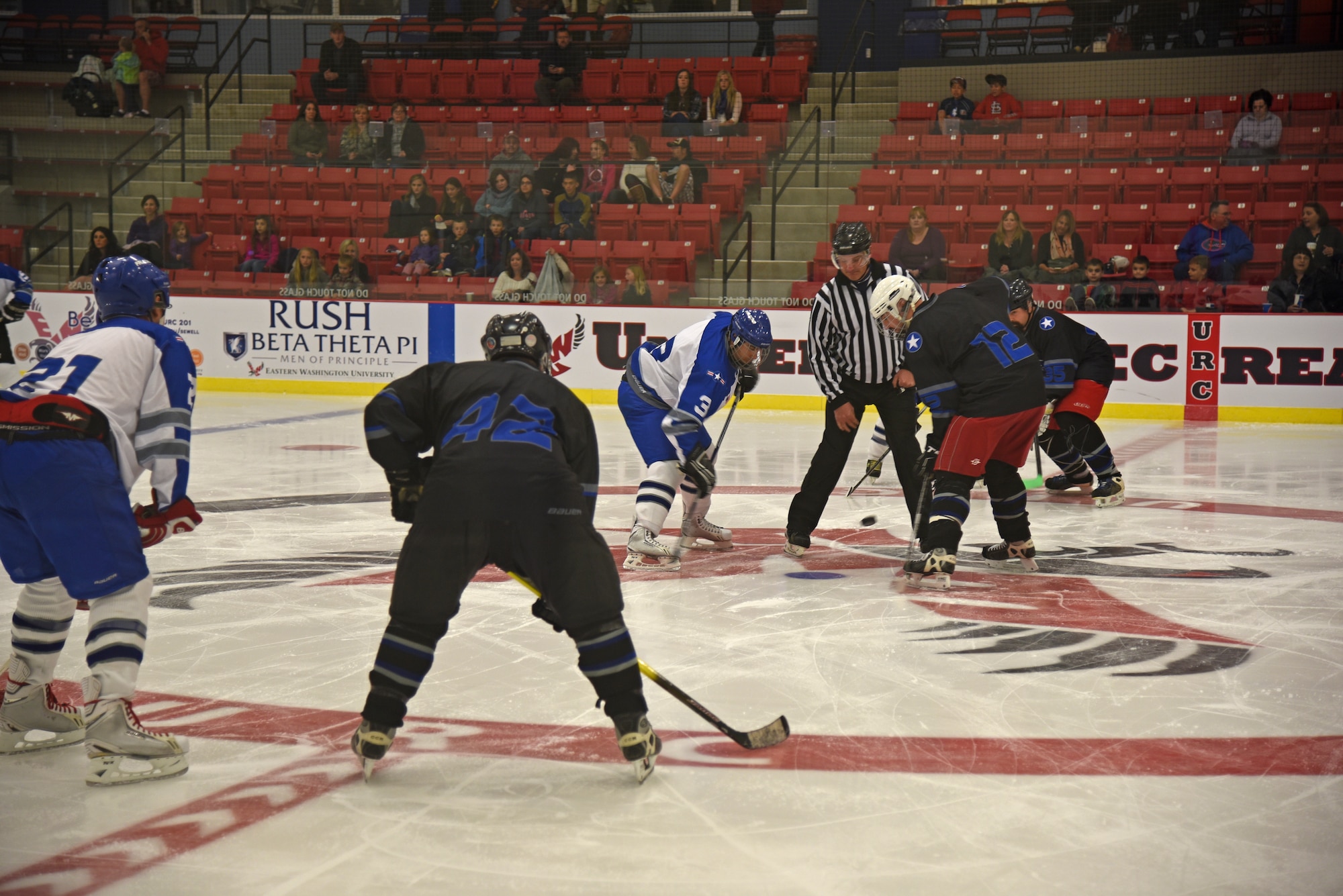 The Fairchild Air Force Base Falcons prepare for game play as the puck is dropped at the beginning of the first period of the Blue and White Game Oct. 23, 2015, at Eastern Washington University’s Recreation Center ice rink in Cheney, Wash. The blue team, coached by Col. Brian McDaniel, 92nd Air Refueling Wing commander, and Chief Master Sgt. Christian Pugh, 92nd ARW command chief, claimed victory in a five to three win over the white team. (U.S. Air Force photo/Airman 1st Class Mackenzie Richardson)
