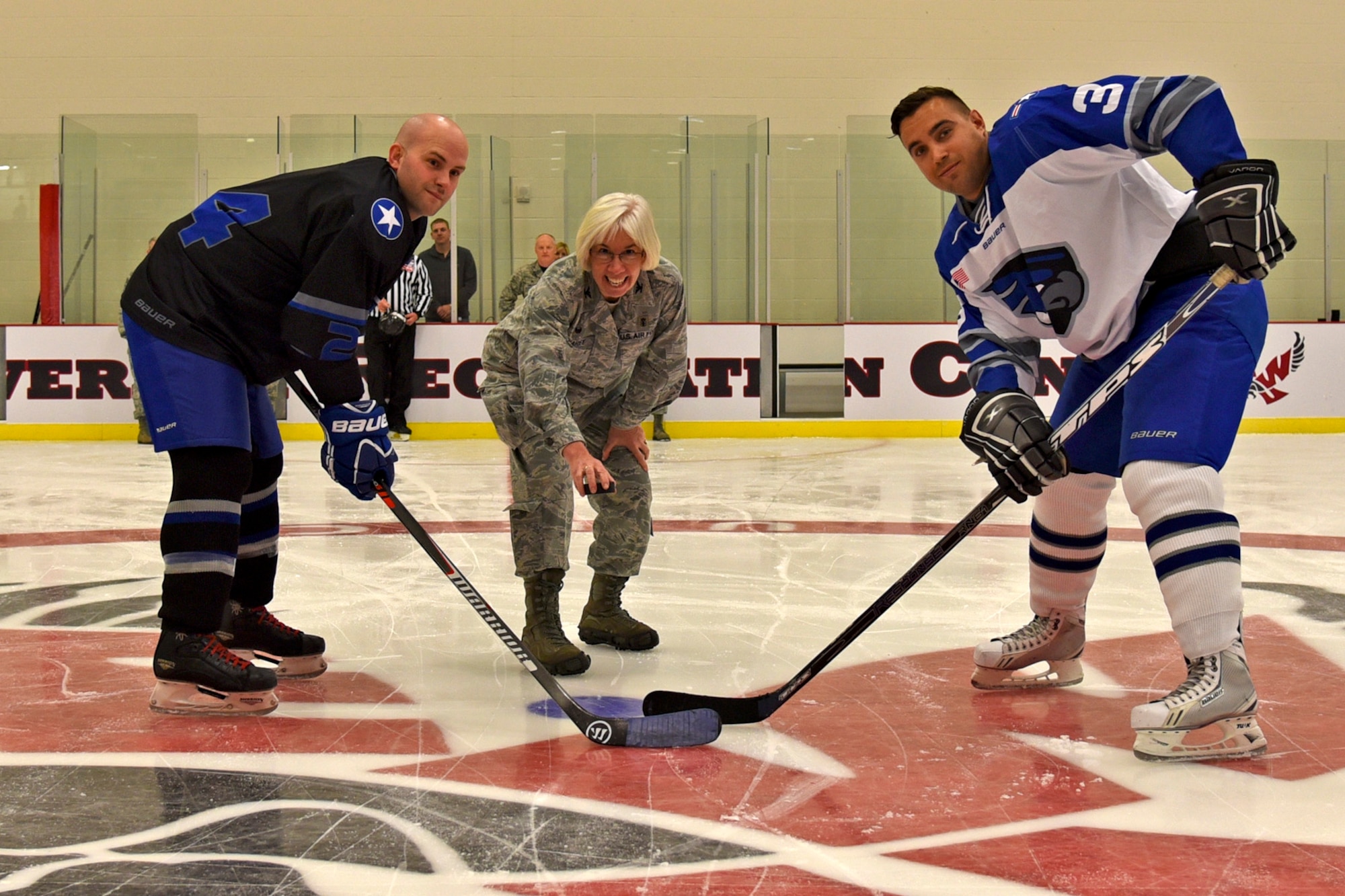 Col. Margaret Carey, 92nd Medical Group commander, drops the puck during the traditional puck drop prior to the Blue and White Game Oct. 23, 2015,  at Eastern Washington University’s Recreation Center ice rink. The Fairchild Air Force Base Falcons host Blue and White games twice a season to help boost morale and create camaraderie. (U.S. Air Force photo/Airman 1st Class Mackenzie Richardson)