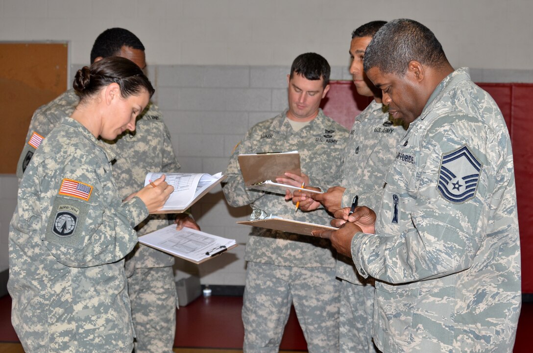 Joint Base Langley-Eustis service members compile their scores after a uniform inspection during the Hampton Roads Junior ROTC Drill Competition at Northampton Community Center in Hampton, Va., Oct. 24, 2015. Seven Junior ROTC units competed, with Bethel High School’s Army Junior ROTC winning the overall competition. (U.S. Air Force photo by Master Sgt. April Wickes/Released)