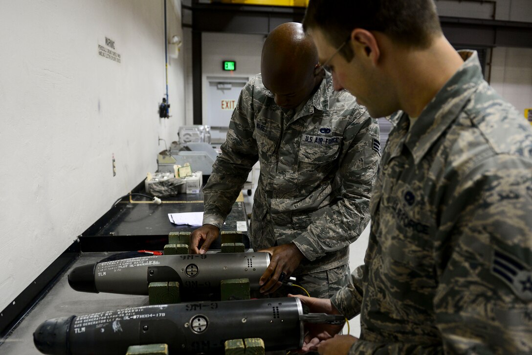 U.S. Air Force Senior Airmen Garrett Peak and Jarrett Ware, 1st Maintenance Squadron ammunition technicians, visually inspect a Guidance Control Section of a training missile at Langley Air Force Base, Va., Oct. 19, 2015. During the training mission, the Airmen determined if the GCS was safe by conducting several safety checks. (U.S. Air Force photo by Airman 1st Class Derek Seifert/ Released) 