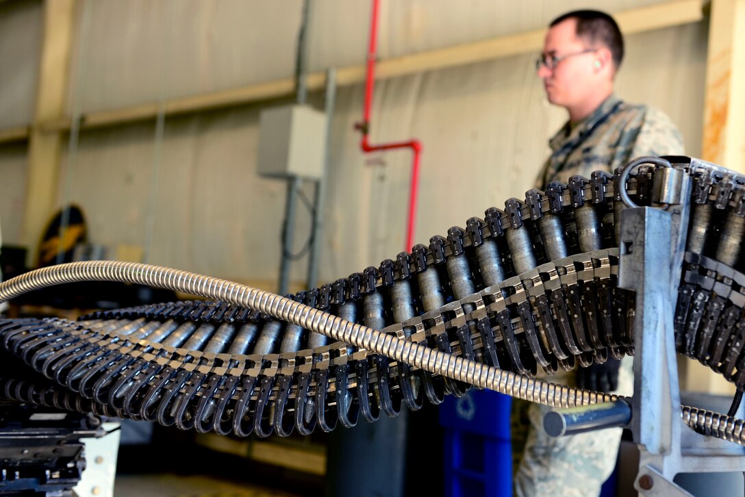 U.S Air Force Airman 1st Class Deacon Tait, 1st Maintenance Squadron conventional maintenance technician, waits as 20 millimeter rounds are uploaded to be transported to the flight line at Langley Air Force Base, Va., Oct. 19, 2015. More than 450 rounds were downloaded, inspected and uploaded into a Universal Ammunition Loader in support of armament training. (U.S. Air Force photo by Airman 1st Class Derek Seifert/ Released)