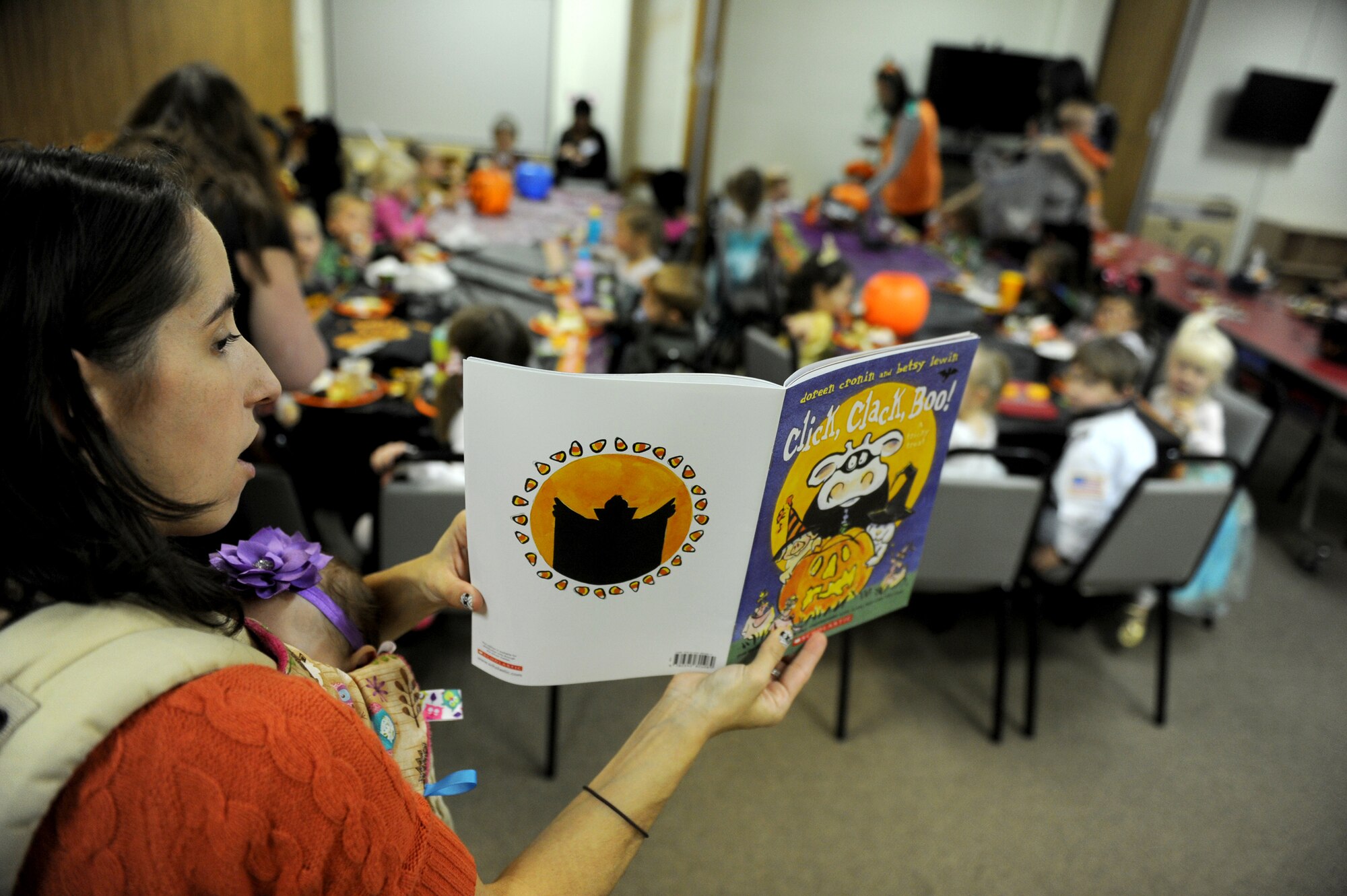 A member from the base Preschool Home School Co-op Group reads a book to children during co-op meeting at Minot Air Force Base, N.D., Oct. 26, 2015. The children were participating in a Halloween party during their weekly co-op meeting which brings children together from different families who are home schooled on Minot AFB. (U.S. Air Force photo by Staff Sgt. Chad Trujillo)