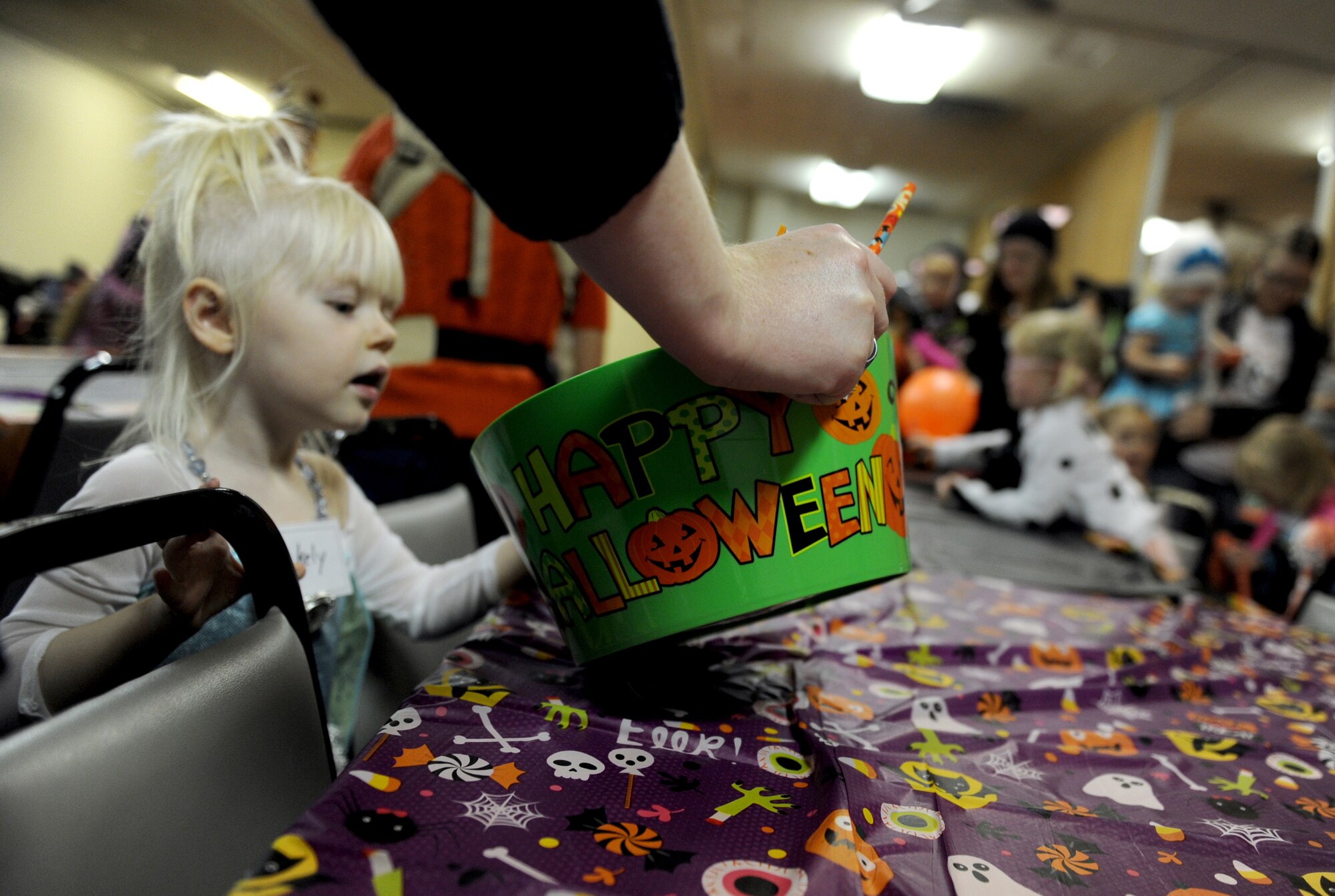 A small child picks out a piece of candy during a pre-school home school co-op meeting at Minot Air Force Base, N.D. Oct. 26, 2015. The small child participated in a Halloween party during their weekly co-op meeting which brings children together from different families who are home schooled on Minot Air Force Base. (U.S. Air Force photo by Staff Sgt. Chad Trujillo)