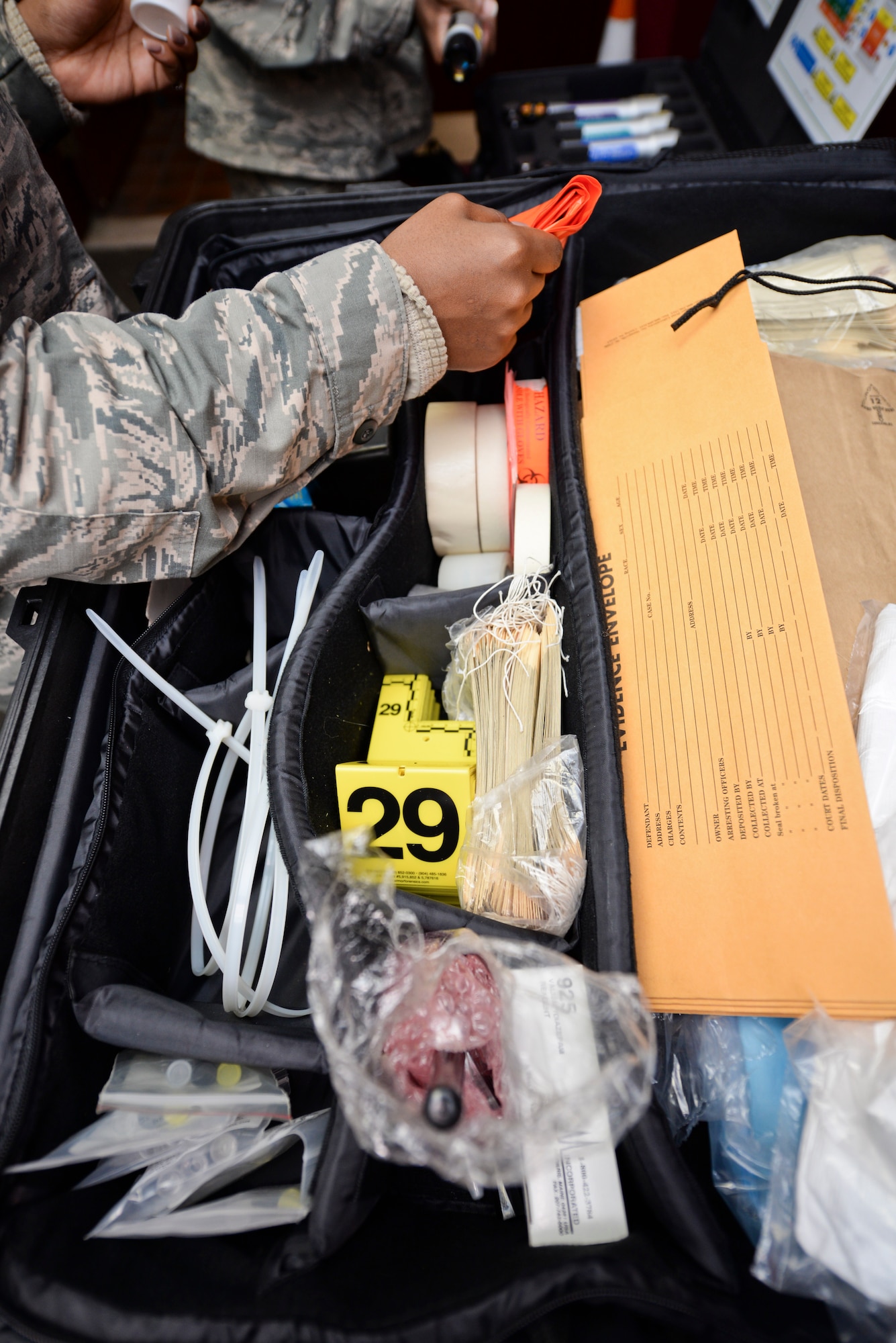 Airmen look through a case of tools from the Office of Special Investigations at Minot Air Force Base, N.D., Oct. 22, 2015. OSI agents led training to share their process for photographing a crime scene. (U.S. Air Force photo/Airman 1st Class J. T. Armstrong)