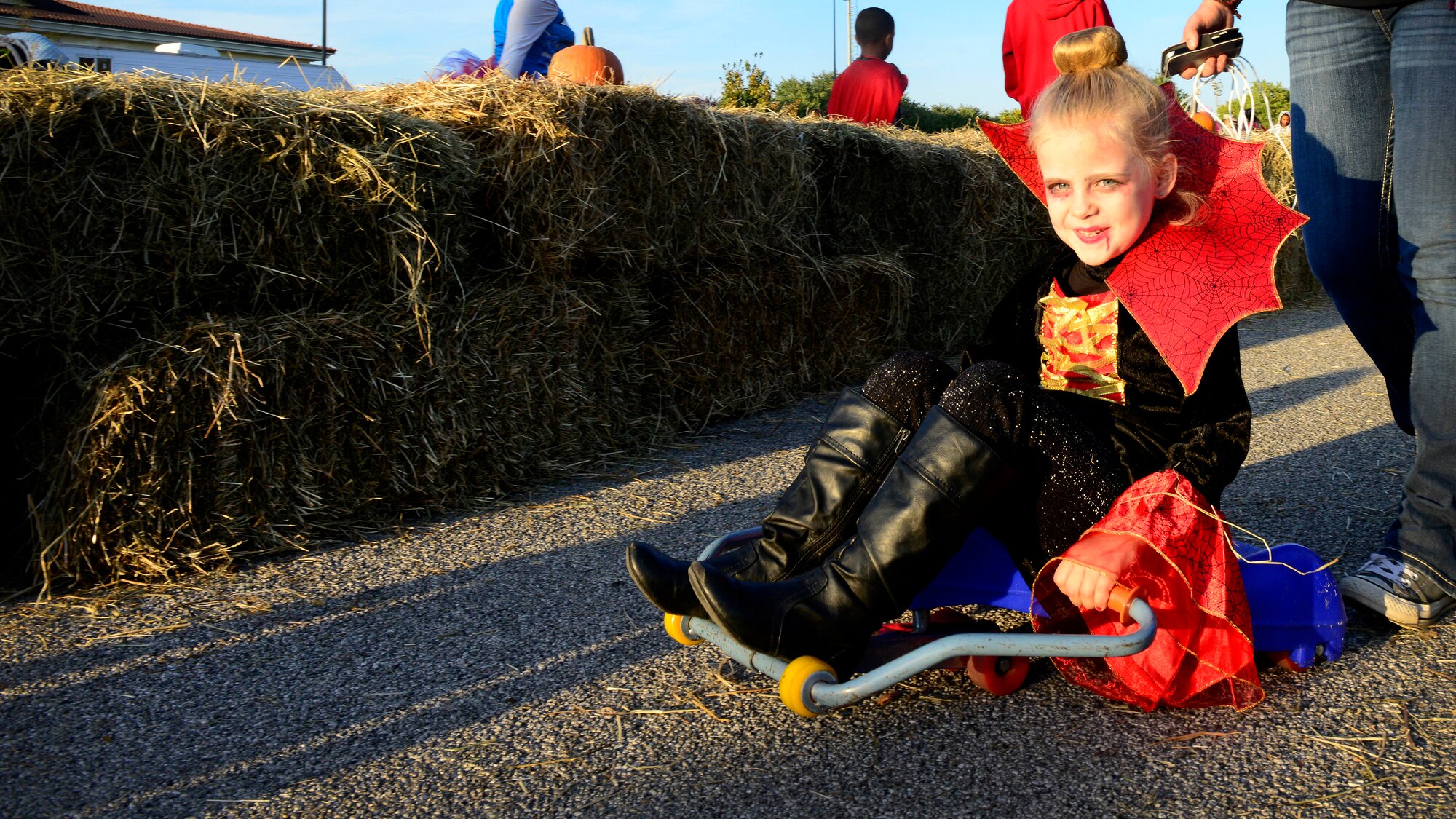 Olivia McNees rides a scooter during “Fall Fest,” Oct. 24, 2015, at Aviano Air Base, Italy. Team Aviano members and the local community came together to celebrate Halloween with children’s games, trick-or-treating, an outdoor movie and a haunted house. (U.S. Air Force photo by Senior Airman Areca T. Bell/Released)