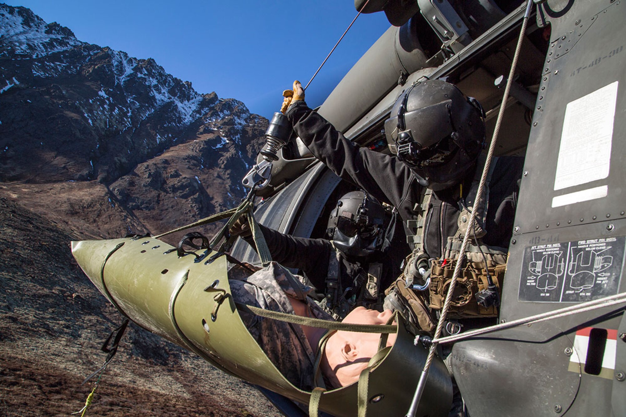 Alaska Army National Guard Staff Sgt. Bradley McKenzie, right, and Staff Sgt. Kevan Katkus, UH-60 Black Hawk helicopter crew chiefs assigned to 1st Battalion, 207th Aviation Regiment, recover a stretcher while conducting rescue hoist training on Joint Base Elmendorf-Richardson, Oct. 21, 2015. The training, which also included deploying a jungle penetrator device, was coordinated with Soldiers assigned to 1st Battalion (Airborne), 501st Infantry Regiment. (U.S. Air Force photo/Alejandro Pena)