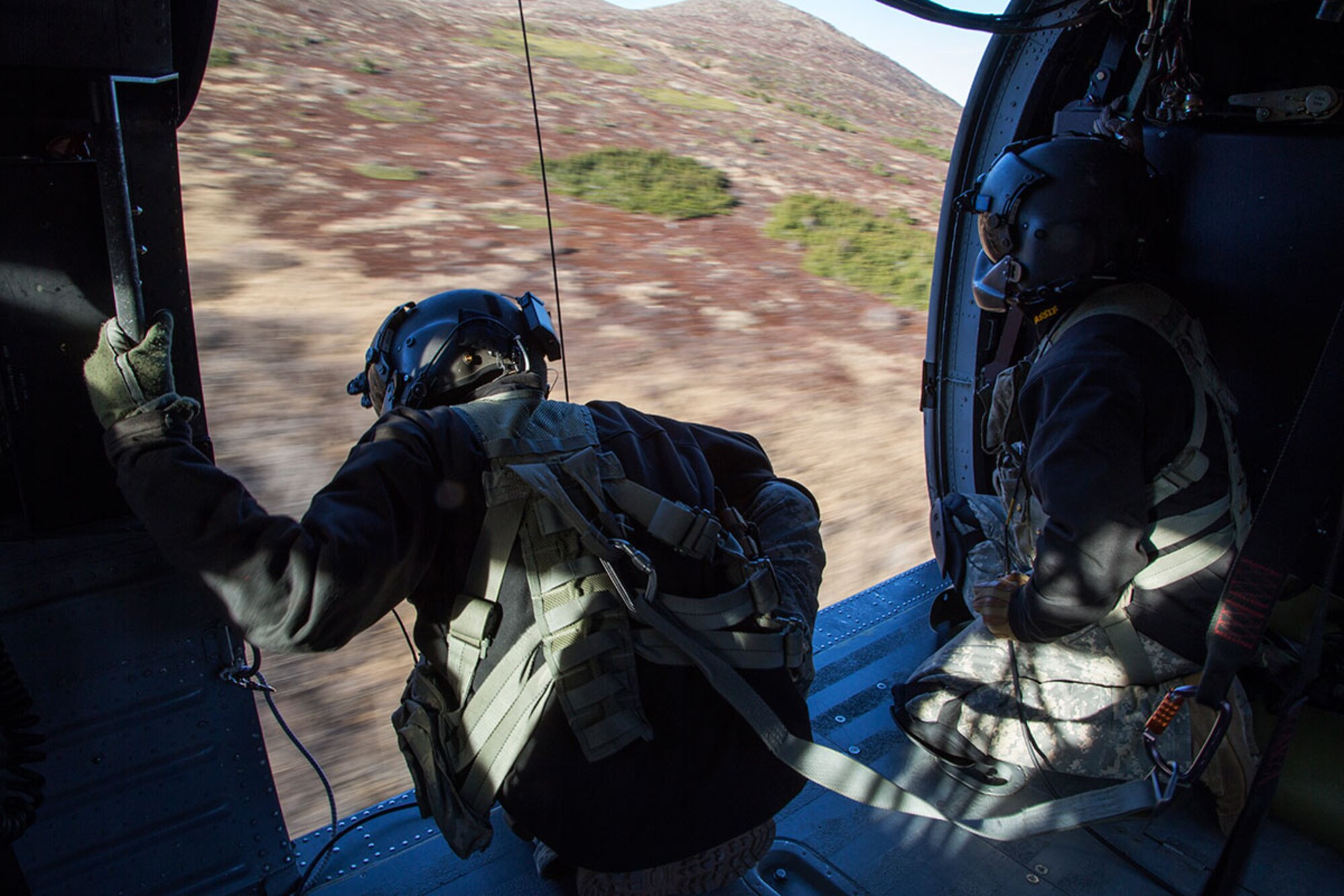 Alaska Army National Guard Sgt. Bradley McKenzie, left, and Staff Sgt. Kevan Katkus, UH-60 Black Hawk helicopter crew chiefs assigned to 1st Battalion, 207th Aviation Regiment, conduct flight operations over Joint Base Elmendorf-Richardson, Alaska, Oct. 21, 2015. The flight operations included rescue hoist training and a casualty evacuation exercise with Soldiers assigned to 1st Battalion (Airborne), 501st Infantry Regiment. (U.S. Air Force photo/Alejandro Pena)