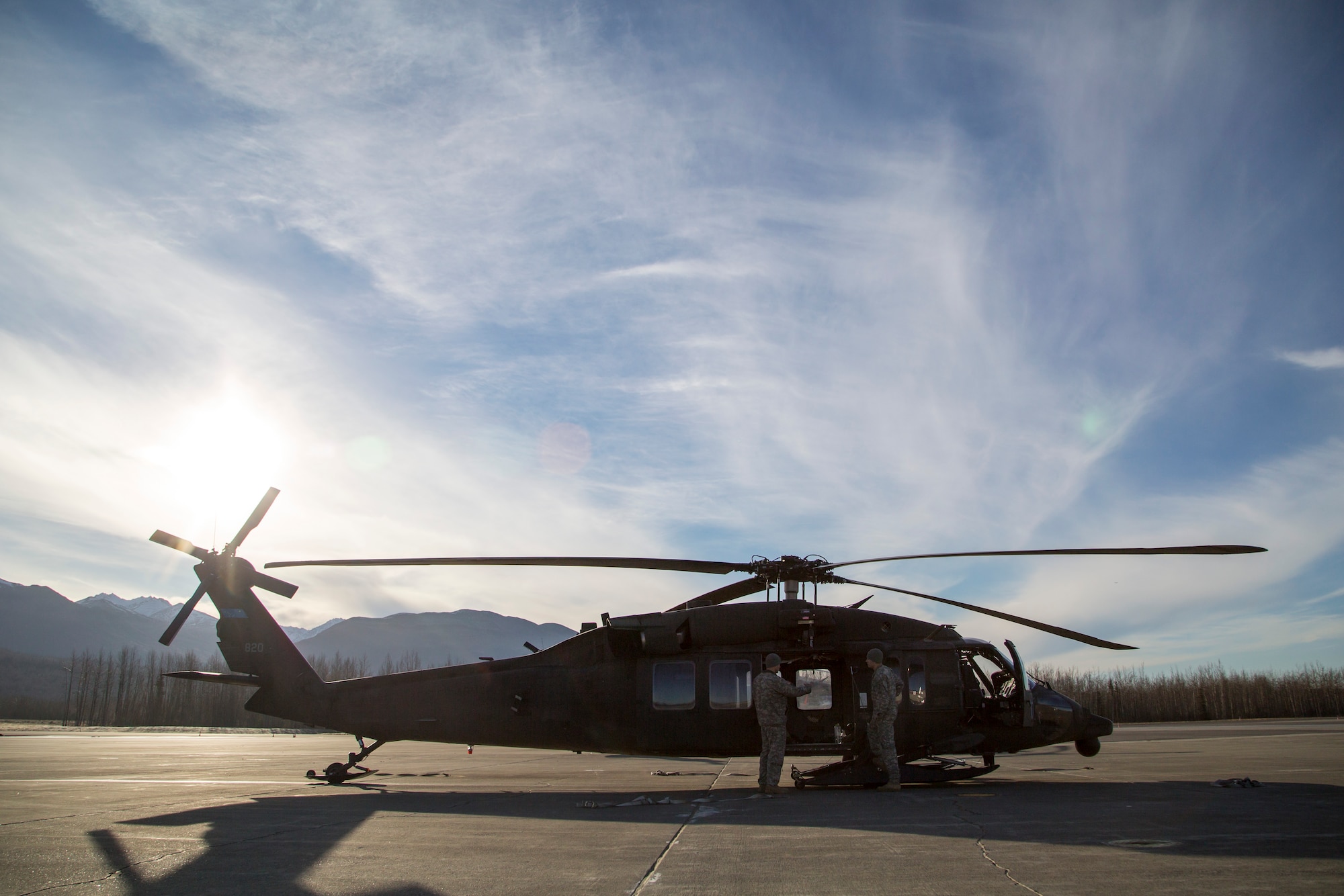 Alaska Army National Guard Chief Warrant Officer 4 Mark Ward, left, and Capt. Zachary Miller, UH-60 Black Hawk helicopter pilots assigned to 1st Battalion, 207th Aviation Regiment, confer with each other before conducting rescue hoist training on Joint Base Elmendorf-Richardson, Alaska, Oct. 21, 2015. The training included deploying a jungle penetrator device and practicing a simulated casualty evacuation with Soldiers assigned to 1st Battalion (Airborne), 501st Infantry Regiment. (U.S. Air Force photo/Alejandro Pena)