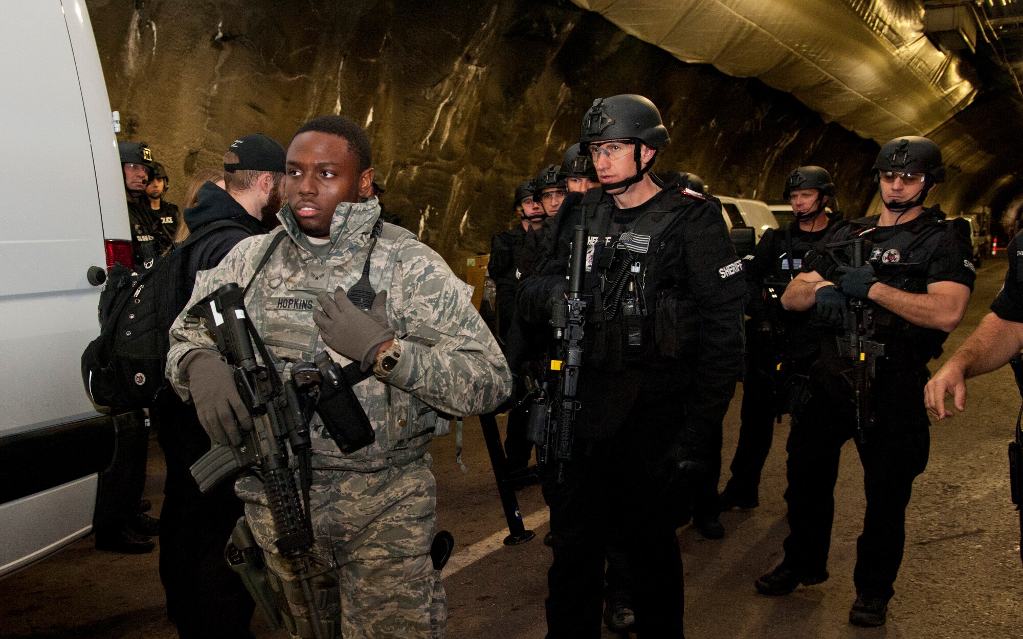 CHEYENNE MOUNTAIN AIR FORCE STATION, Colo. – Airman 1st Class Devin Hopkins, 721st Security Forces Squadron, leads El Paso County Sheriff’s SWAT Team into Cheyenne Mountain Air Force Station’s underground complex during an exercise, Oct. 22, 2015.  The SWAT Team was called to respond to an active shooter turned hostage exercise scenario in the systems center to negotiate with the simulated hostage taker and help with simulated victim evacuation. (U.S. Air Force photo by Senior Airman Tiffany DeNault))