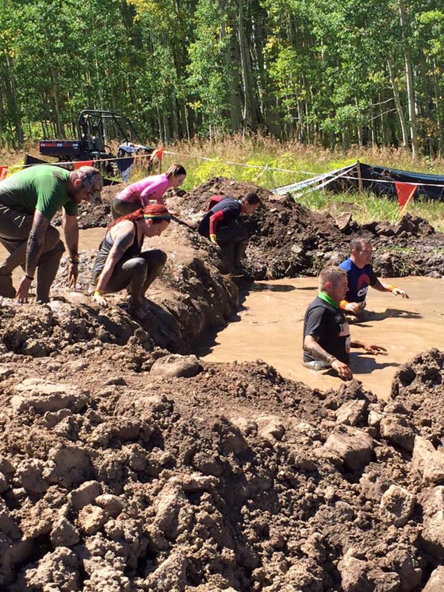 PETERSON AIR FORCE BASE, Colo. -- Tech Sgt. Jason Sheppard, 21st Logistics Readiness Squadron, wades through a mud pit during a Tough Mudder event over the summer while Tech Sgt. Allan Skelton, also 21st LRS, left, prepares to take the plunge. The Team Pete partners already began planning their next event before this one was finished. This was Sheppard’s third such race and Skelton’s first. (courtesy photo)