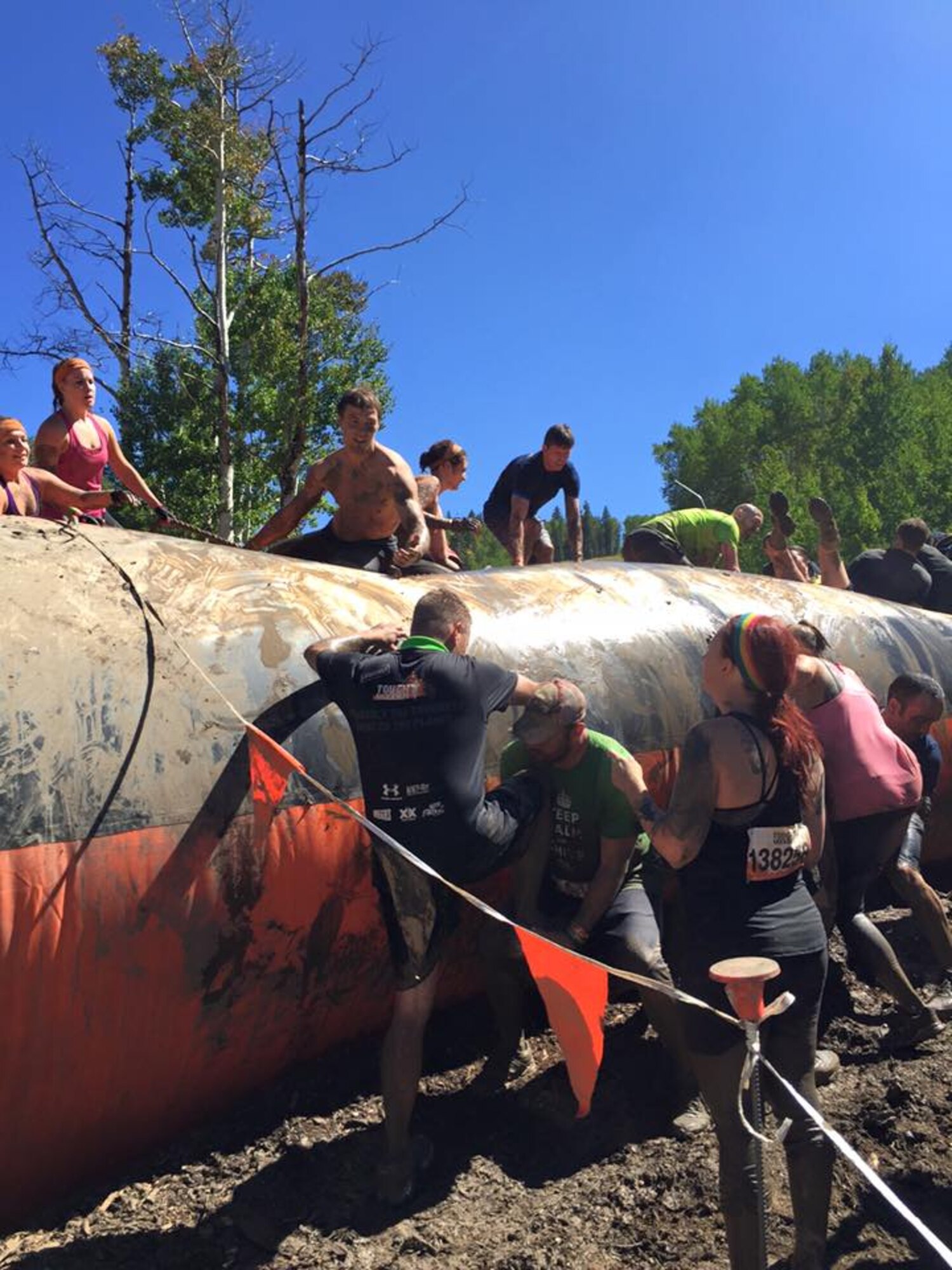 PETERSON AIR FORCE BASE, Colo. -- Tech Sgt. Allan Skelton helps Tech Sgt. Jason Sheppard, both 21st Logistics Readiness Squadron, climb an obstacle during a Tough Mudder event over the summer. It was Skelton’s first obstacle race and Sheppard’s third. They began planning their next event before this one was completed. (courtesy photo)