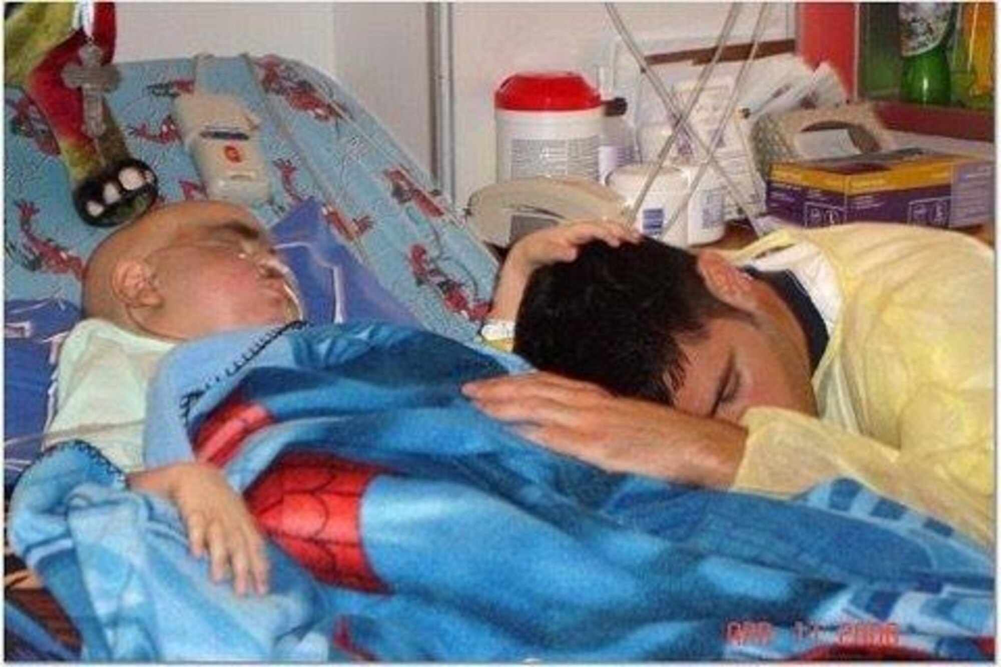 PETERSON AIR FORCE BASE, Colo. -- Tech. Sgt. Billy Gazzaway, 21st Communications Squadron deputy chief of infrastructure, sleeps next to his son, Kadin, after a stem cell transplant. Kadin fought a hard battle, but passed away in 2006 from leukemia. Gazzaway struggled with the loss of his son, turning to alcohol to cope. After admitting he needed help, he was able to begin the healing process. (courtesy photo)