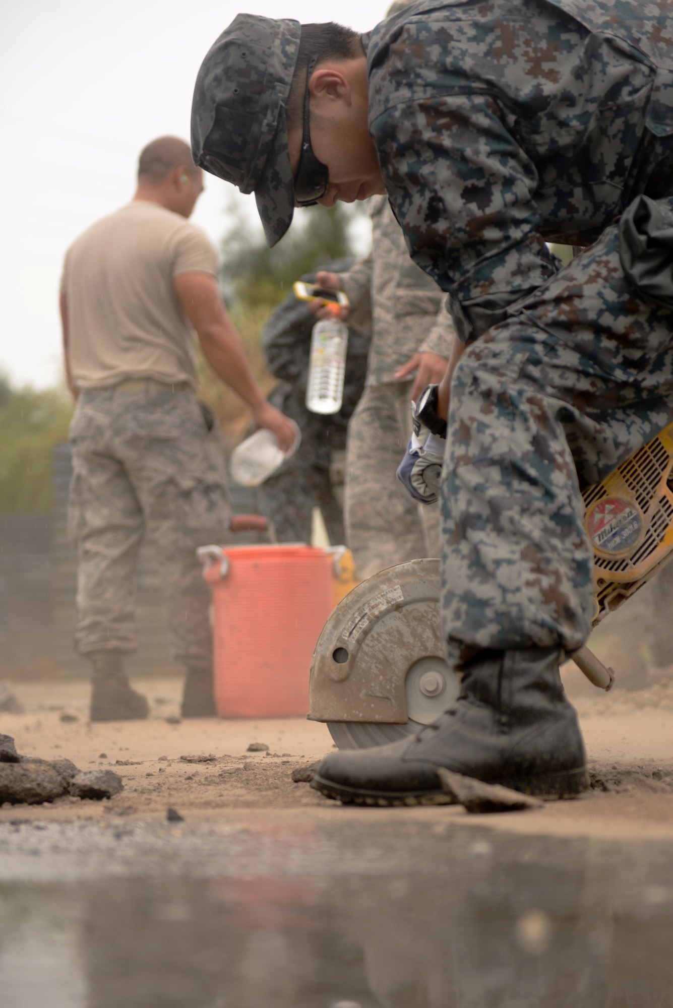 Japan Air Self Defense Force Staff Sgt. Mutsuhiro Karasuyama, Southwestern Composite Air Division civil engineer, cuts out a slab of concrete during a rapid runway repair simulation, Oct. 22, 2015, on Kadena Air Base, Japan. JASDF civil engineers from Naha Air Base trained side-by-side with Airmen from the 18th Civil Engineer Squadron to build bilateral relations and improve their combined runway repair capabilities. (U.S. Air Force photo by Senior Airman Omari Bernard)