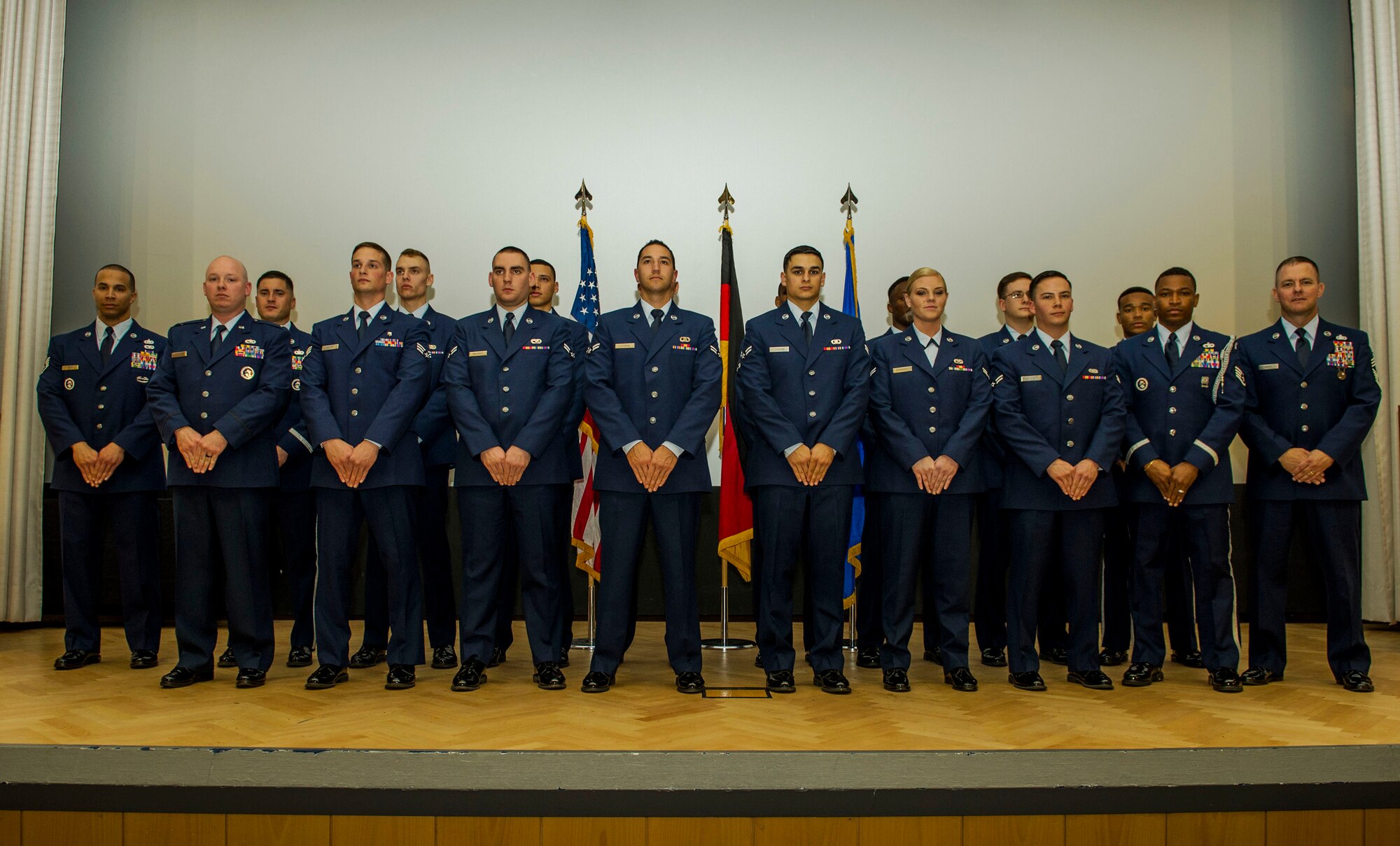 The graduating class 16-1 of the base Honor Guard’s training course pose for a photo after their graduation ceremony inside the base theater at Spangdahlem Air Base, Germany, Oct. 23, 2015. Twelve of the original 20 recruits completed and graduated the ceremony after five days of training. (U.S. Air Force photo by Airman 1st Class Timothy Kim/Released)