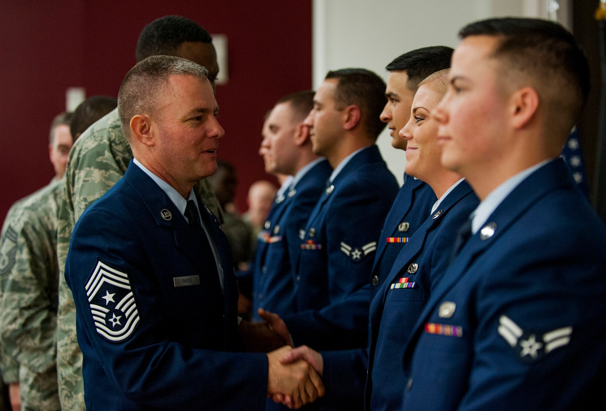 U.S. Air Force Chief Master Sgt. Brian Gates, 52nd Fighter Wing command chief, left, congratulates one of the new ceremonial guardsmen after the base Honor Guard training graduation ceremony inside the base theater at Spangdahlem Air Base, Germany, Oct. 23, 2015. As Spangdahlem’s newest Honor Guardsmen, the graduates will travel in the largest area of responsibility in United States Air Forces in Europe, representing Spangdahlem and the USAF in all formal ceremonies requiring their service. (U.S. Air Force photo by Airman 1st Class Timothy Kim/Released)