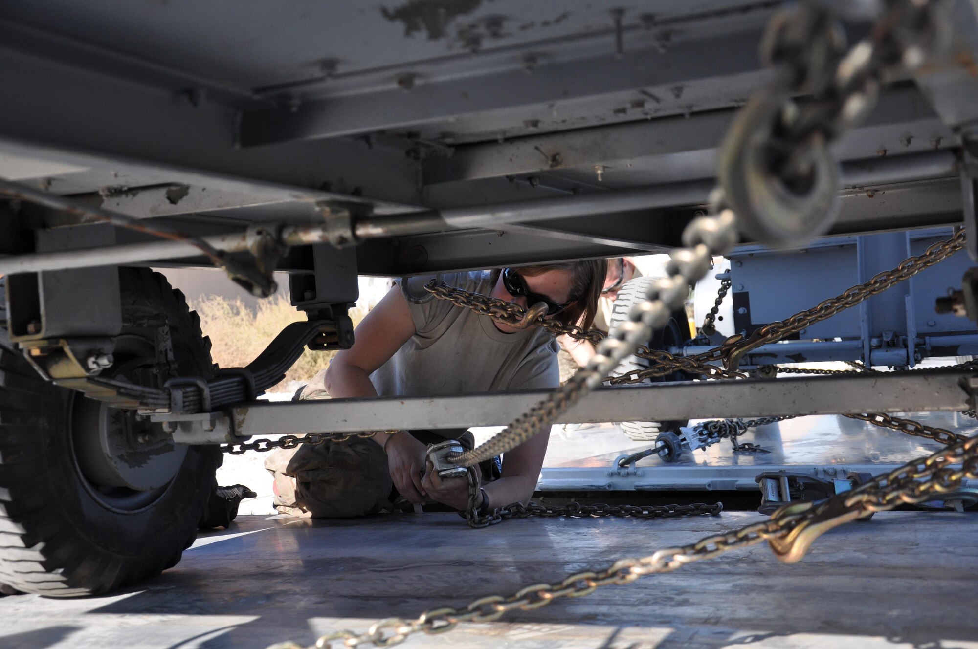 Airman 1st Class Jaycie Thompson, 455th Expeditionary Maintenance Squadron Aerospace Ground Equipment flight technician, deployed from Aviano Air Base, Italy, ratchets down a piece of deployed equipment Oct. 27, 2015, at Bagram Airfield, Afghanistan. The AGE flight is responsible for the maintenance and inspection of 309 pieces of equipment used on the flight line and around base. (U.S. Air Force photo by Tech. Sgt. Nicholas Rau/Released)